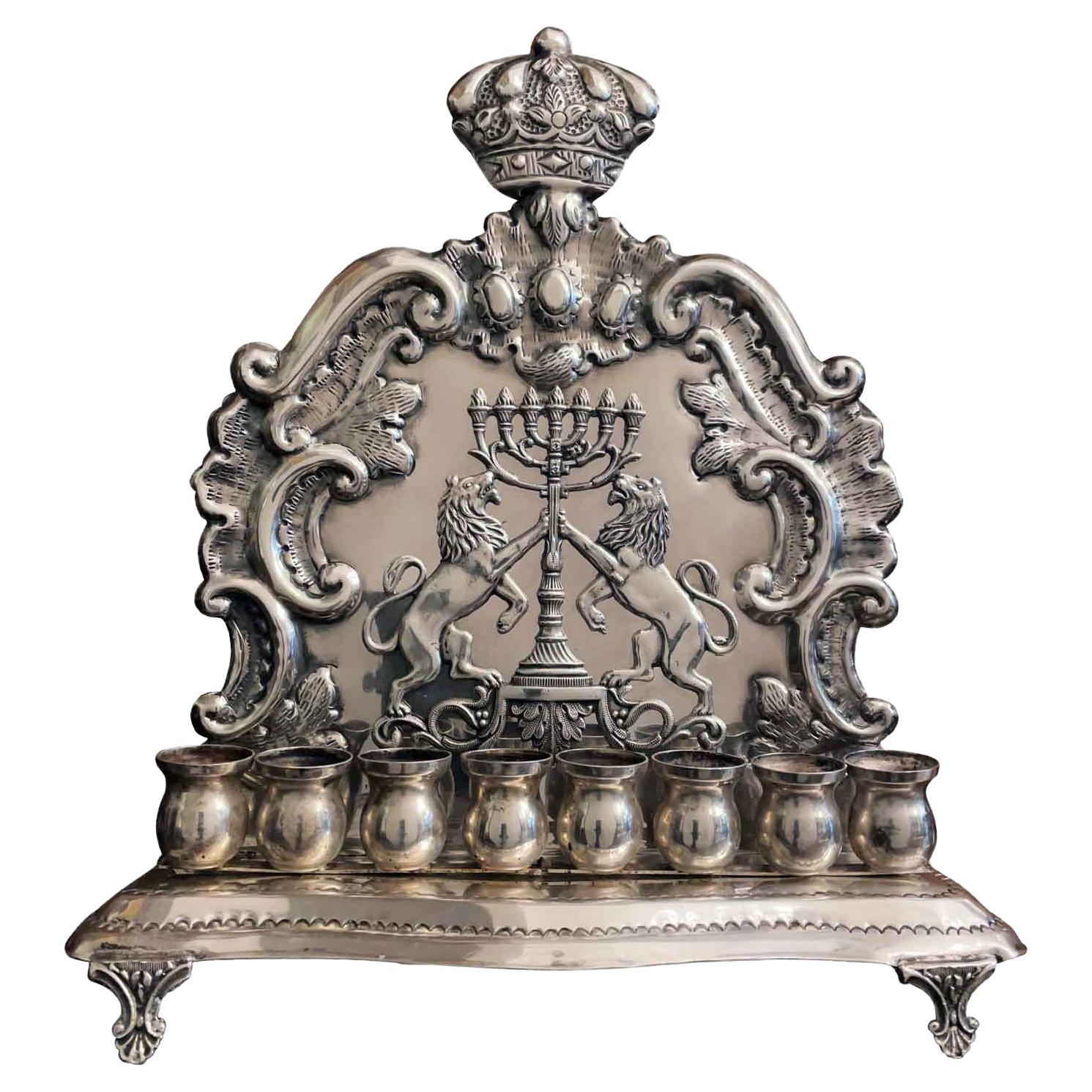 Antique cast and plate silver 800/000 Hanukkah lamp, an oil lamp for the Jewish festival of lights made in Italy in the early 20th century in good condition. This Judaica artwork featuring a shaped backplate in silver foil, embossed with a scrolling