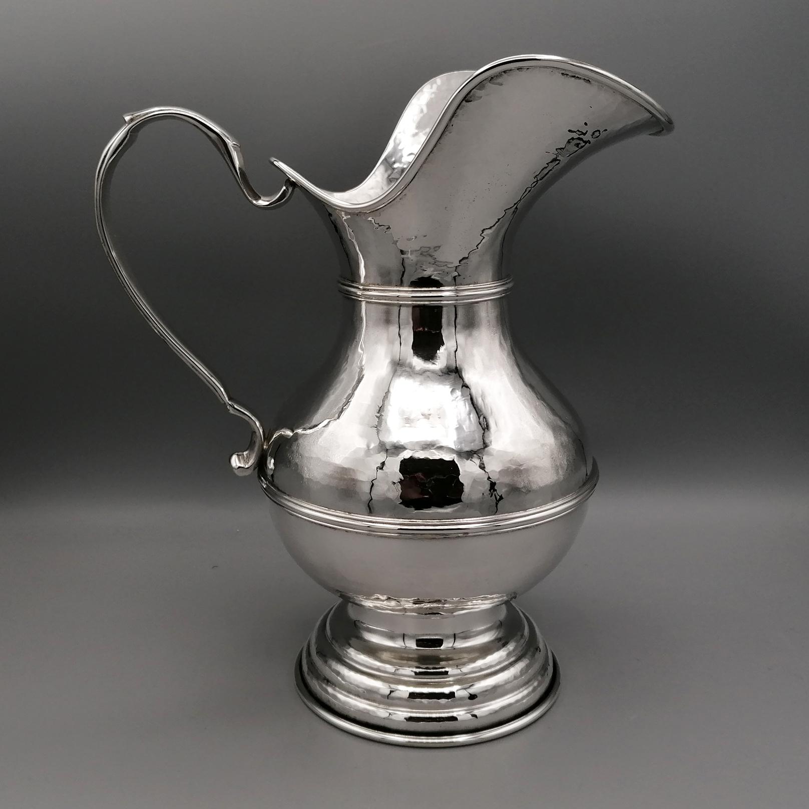 Hammered jug in 800 solid silver.
The pitcher, or pouring vessel, was hand made and subsequently hammered.
An important round base with a stepped design guarantees its stability.
The handle was made with the fusion technique and subsequently