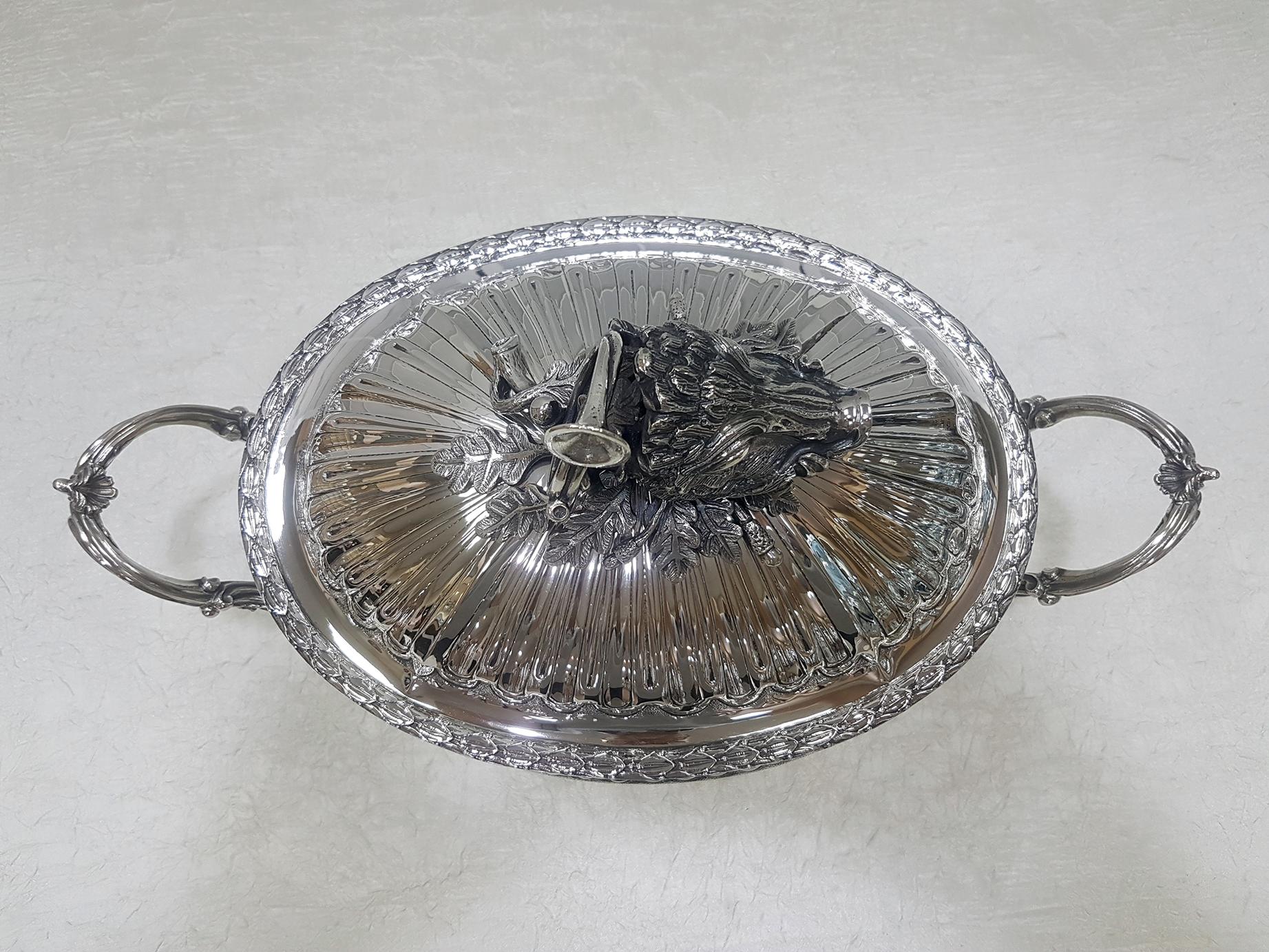 Gorgeous solid silver tureen in Empire style on feet with handles.
The body of the tureen is completely hammered by hand, embossed and chiseled with the typical designs of the Empire style.
The handle of the lid was made in fusion to depict a
