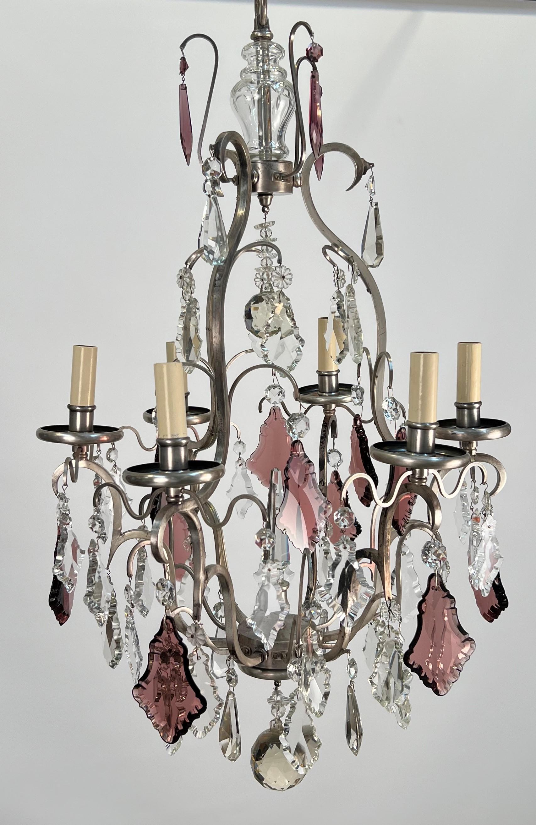A handsome 20th century Italian silvered bronze & crystal Louis XVI style chandelier featuring amethyst accent crystals. The silvered bronze has developed a nice and uneven patina. From the photos one can see varying degrees of un-evened darkened