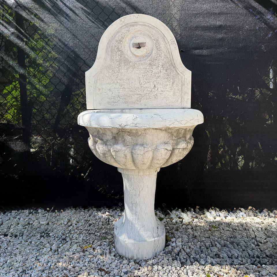 Kleines Wandwasserspiel aus Marmor mit Muschelbecken. Leichte Verblassung, altersbedingte Kratzer. Alters- und gebrauchsbedingte Abnutzungserscheinungen. Circa 20. Jahrhundert, Italien. 