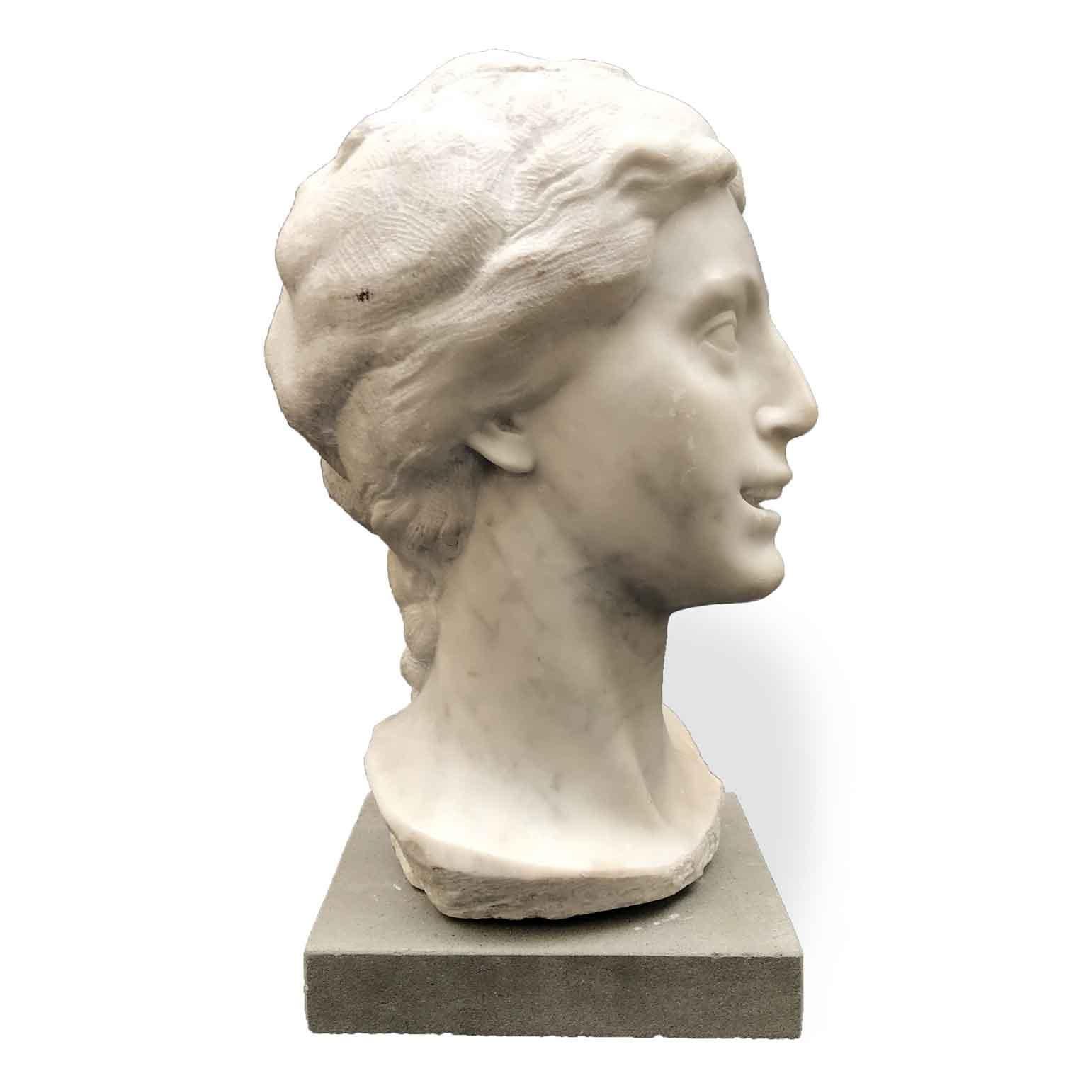 A 20th Century Italian white marble bust of a smiling girl, a carved Carrara marble figural sculpture, signed on the base by the Italian artist Aurelio Bossi, 1884-1948, whose sculptures are displayed at Pinacoteca di Brera in Milan, whereas at the