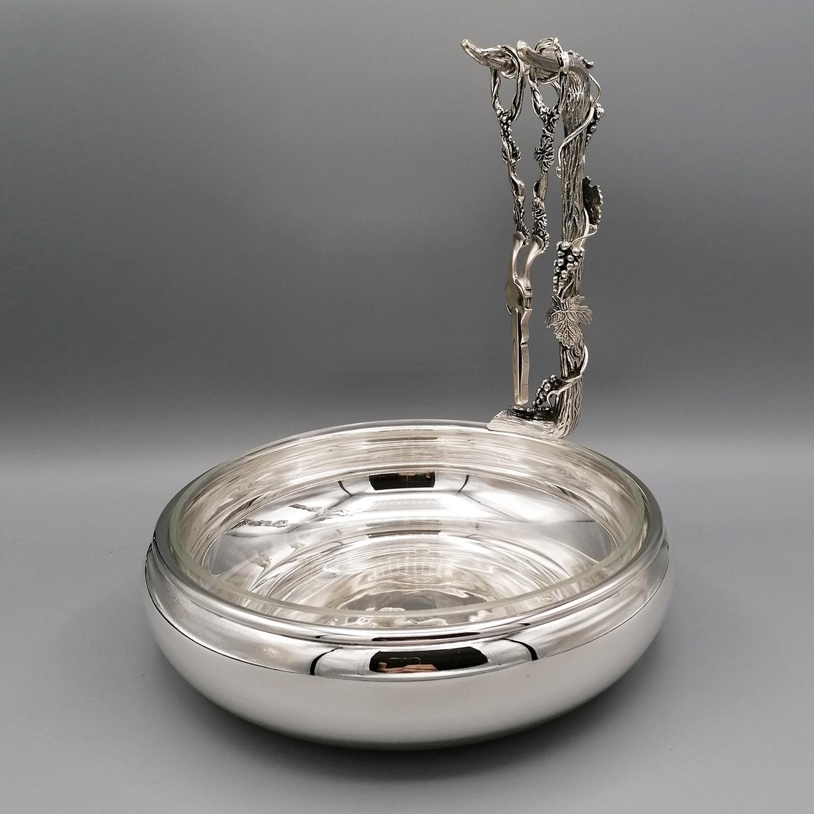 Bowl for grapes with completely smooth with inside a crystal for the bunches of grapes.
A branch with grapes and leaves is welded on the edge, again in solid silver made with the fusion technique and finished with chisel.
The branch in the end