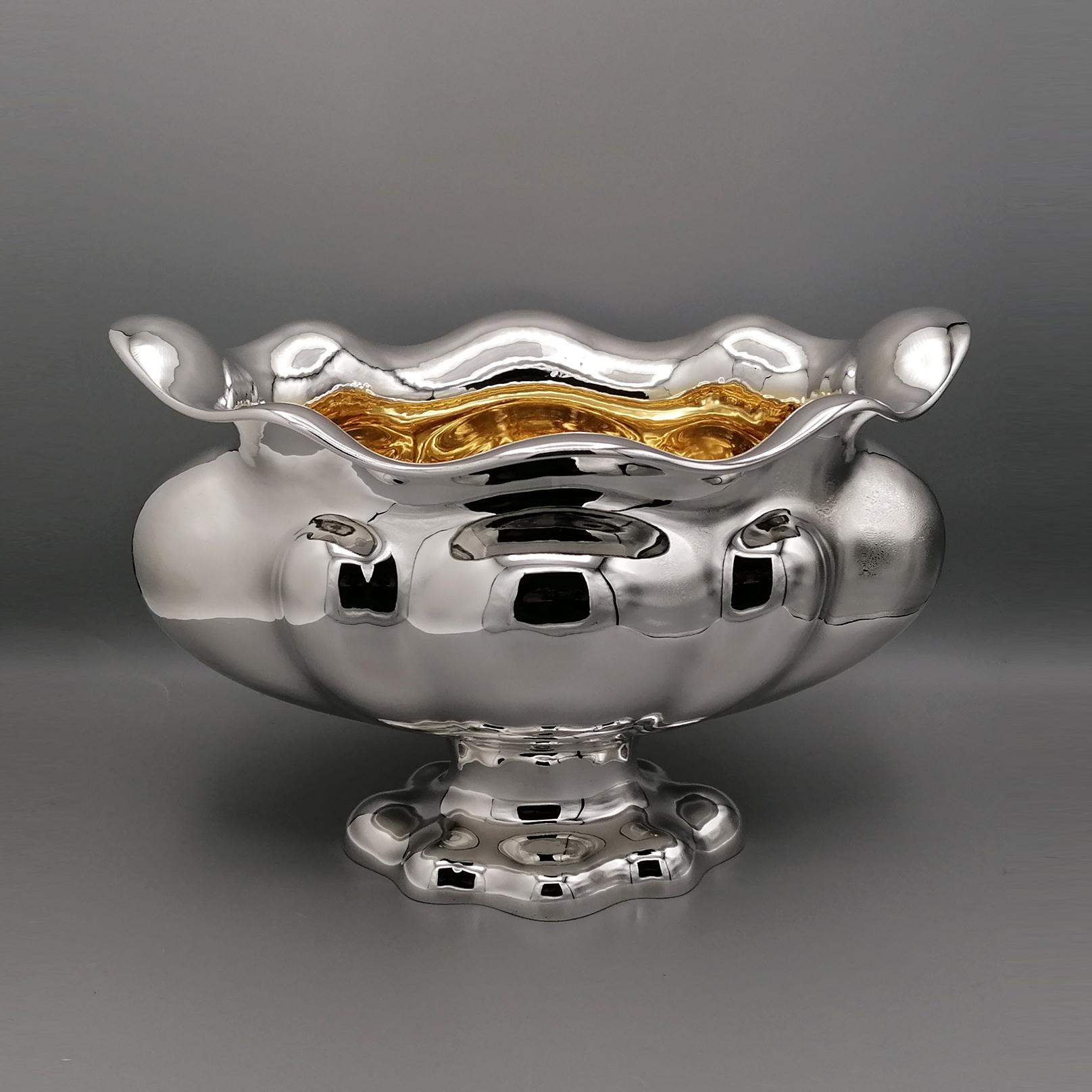 Oval centerpiece completely handmade and with 24kt golden internal finish.
The piece was modeled by hand from a flat slab of solid 800 silver, padded and embossed with ashlar motif of different sizes.
The upper part of the centerpiece has been