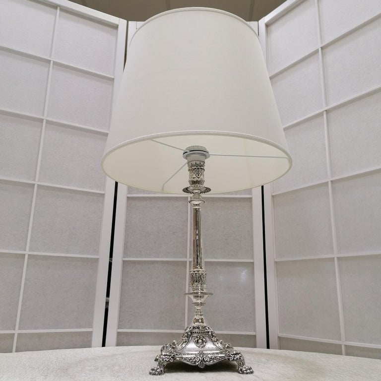 800 silver table lamp.
The lamp is in Empire style and has been finished with chisel.
The stem is smooth in the central part while the classic palm leaves that characterize the empire style have been chiseled in the upper and lower parts. 
The