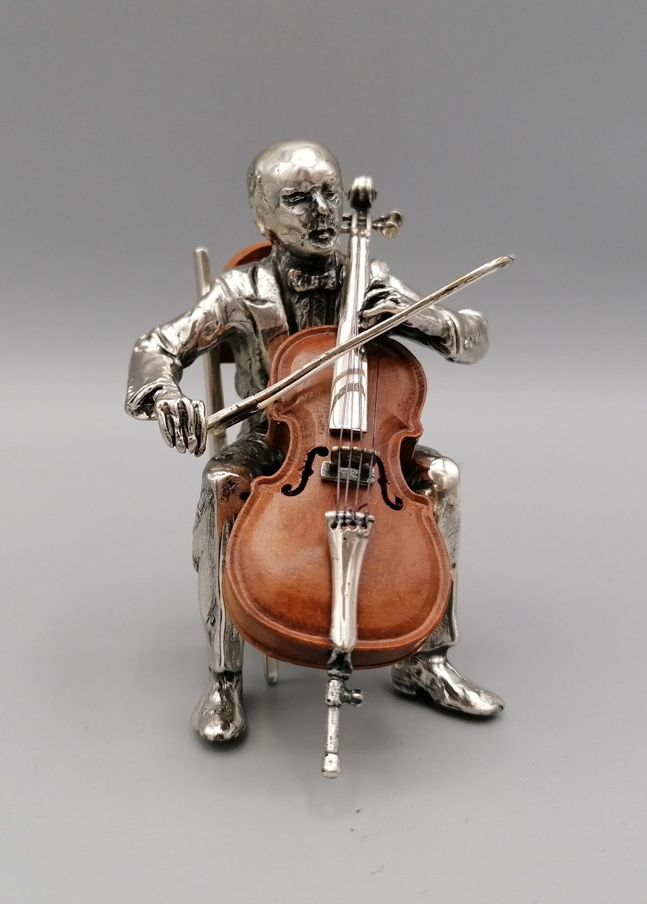 Cello player in 800 solid silver. The cello is in briar with silver details.
The cello bow is in silver.
The player and the cello are positioned on a briar and solid silver chair.
Silver 150 grams circa.
