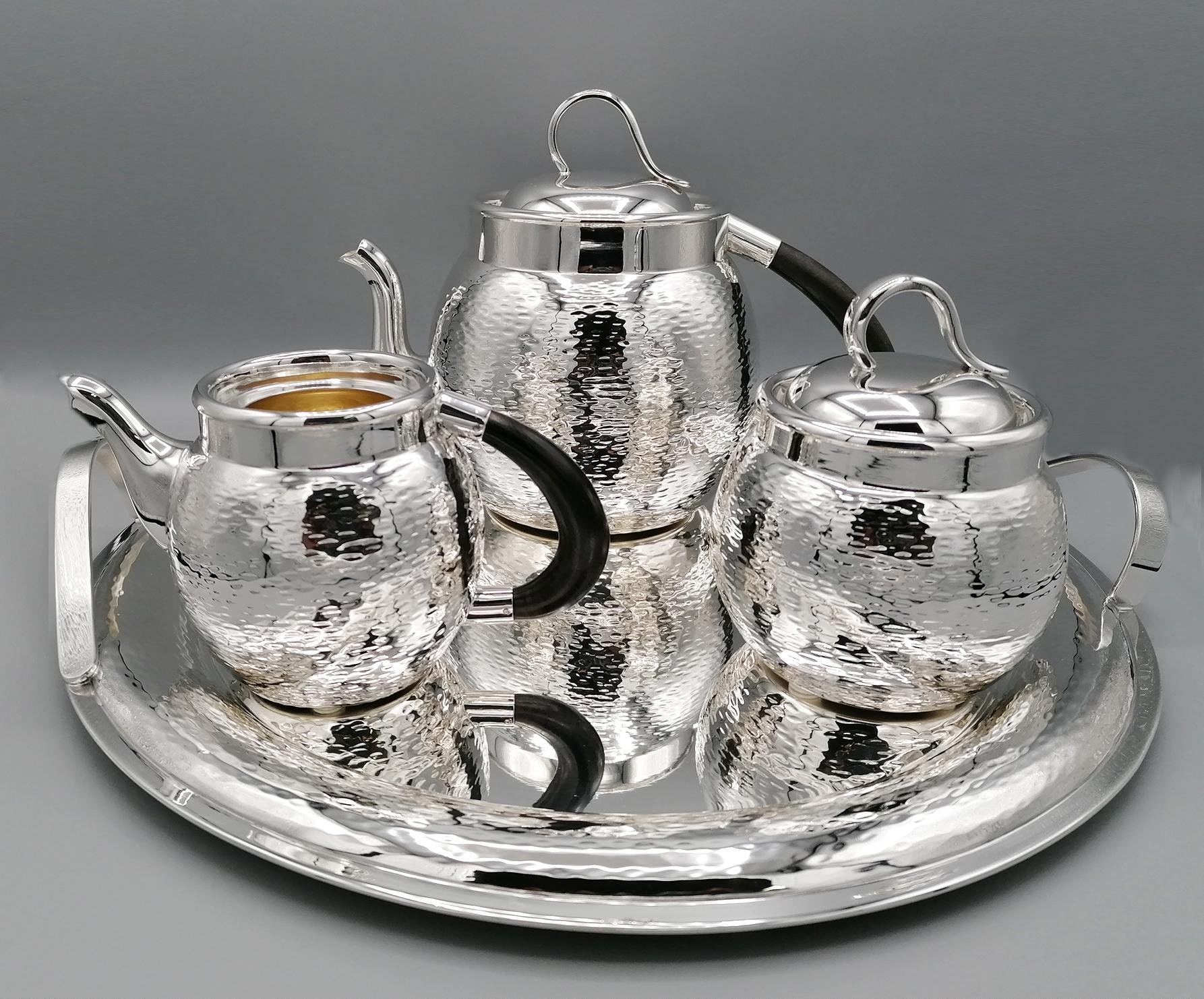 Round 800 silver tea set with wooden handles. The rounded body is hammered with the 