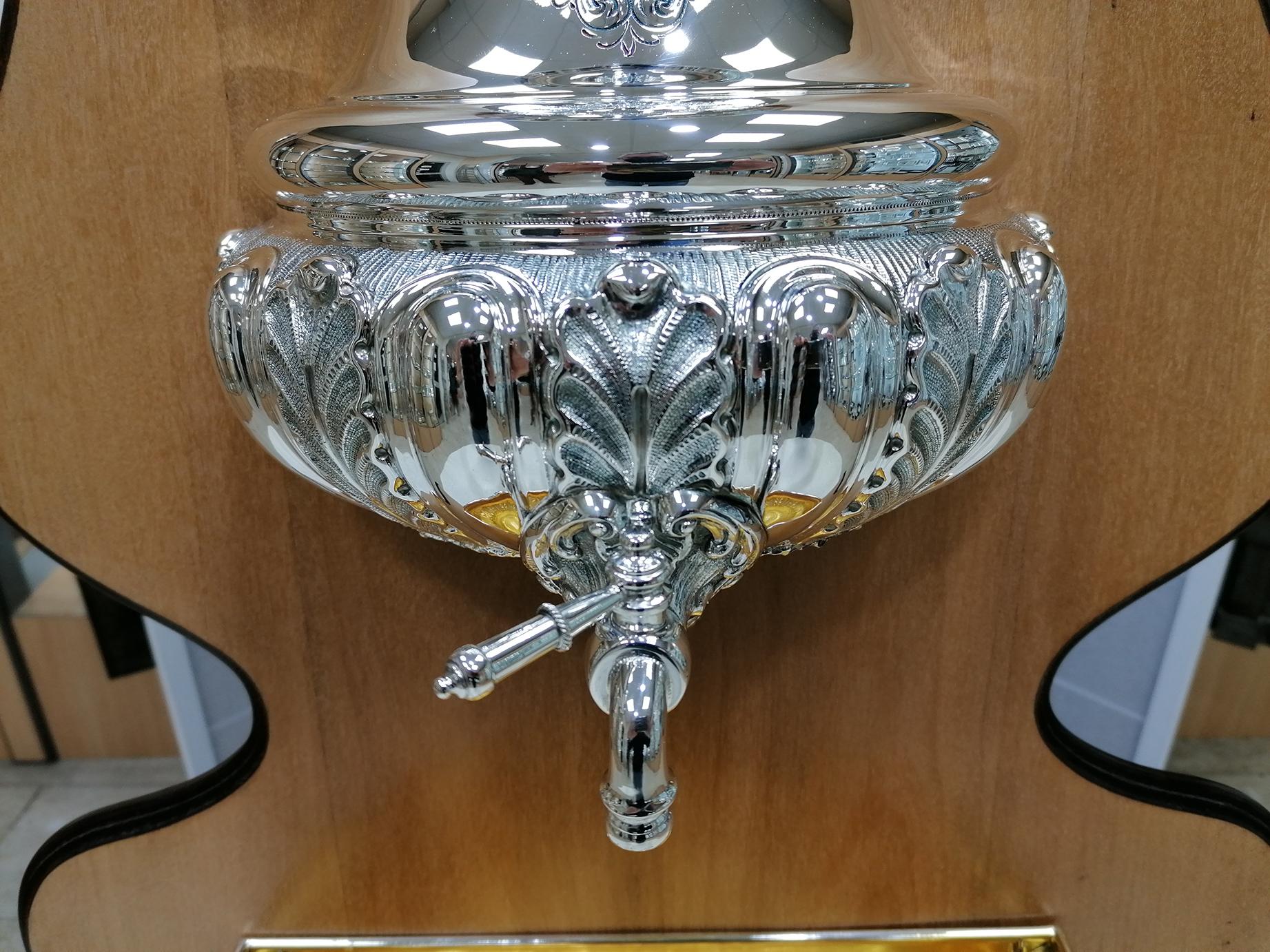 Holy water stoup in 800 solid silver.
Made entirely by hand, embossed and chiseled with leaves and pods motif. The lid is removable to allow water to be refilled. The lower part of the water collector is always embossed and chiseled with the same