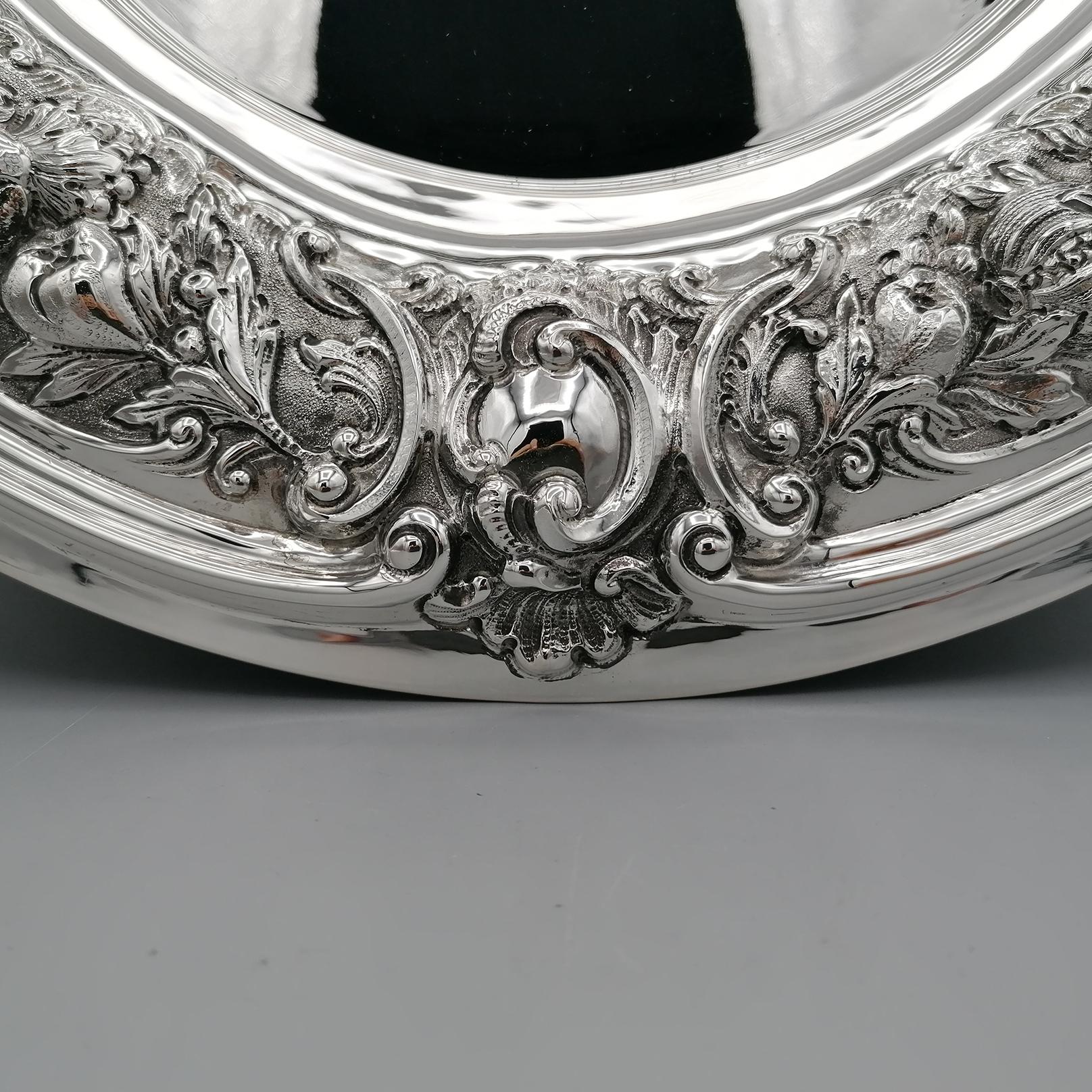 Baroque style centerpiece in 800 solid silver, completely handmade and subsequently embossed and chiseled.
The edge of the centerpiece was embossed with fruit motifs and masks, typical of the Baroque period.
The outer edge and the part of the