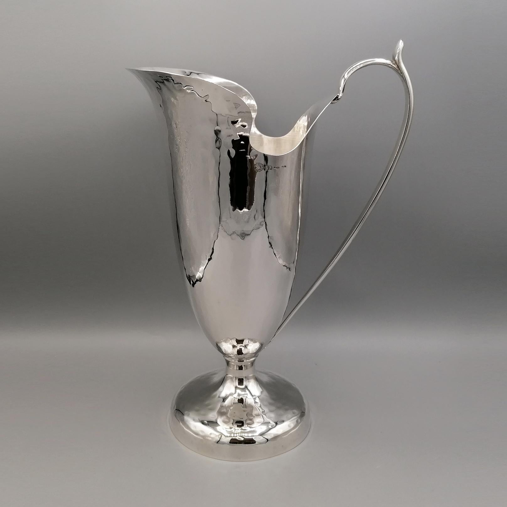 Pitcher in 800 silver handmade in Italy.
The jug was made from a silver plate, shaped and welded.
The imposing base of the jug, round in shape, is hammered and proportioned to give perfect stability to the whole object.
The body branches out from