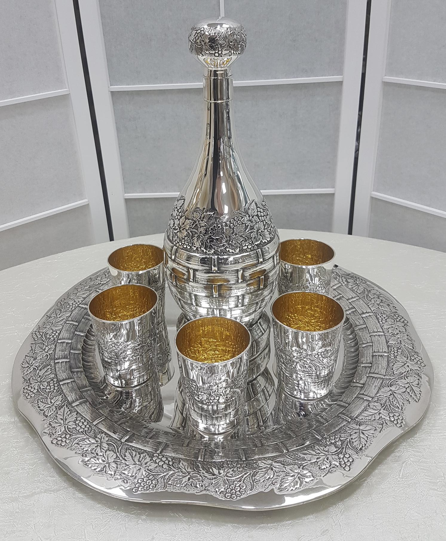 Important silver wine set consisting of tray, bottle and 6 beakers.
The tray has a round shape with an embossed and chiseled edge with bunches of grapes, leaves and wood of the wine vat.
The bottle in the shape of a flask always embossed and