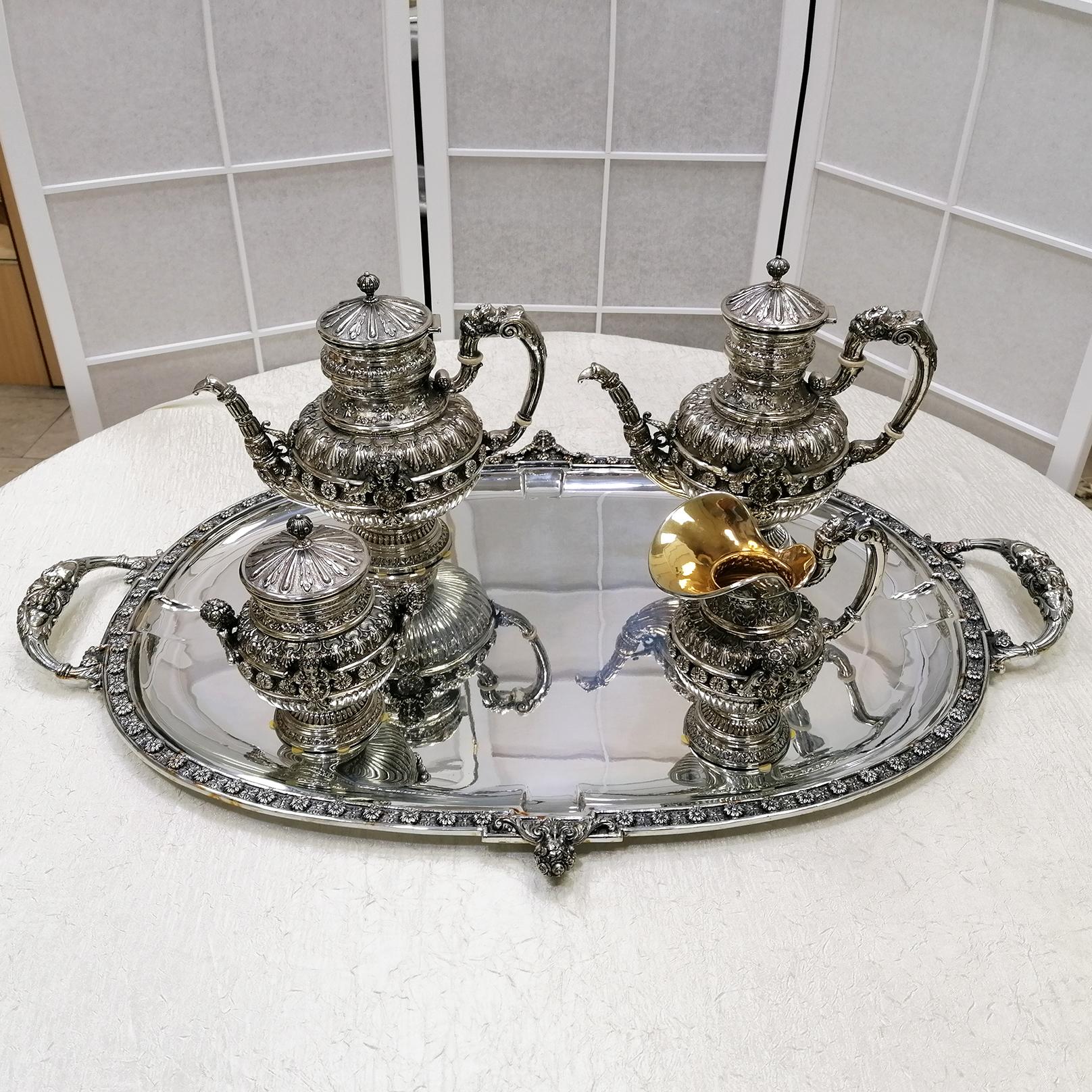 A magnificent, Russian style tea or coffee set on a salver. The tray, made from plate silver, was completely hand-crafted from a raw sheet and its outer rims are embellished with a border of alternating rose-buds and flowers set against a burnished