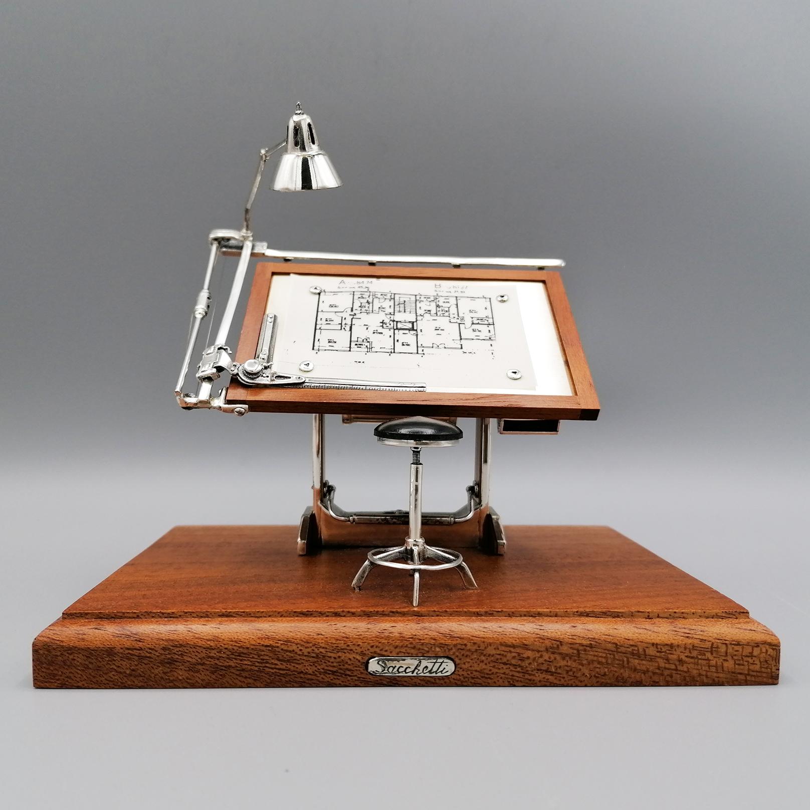 Miniature in sterling silver and walnut burl depicting drafting machine and stool.
The miniature is made entirely by hand and treated in detail by the master craftsman 
Sacchetti - Arezzo - Tuscany
Wooden base.
 