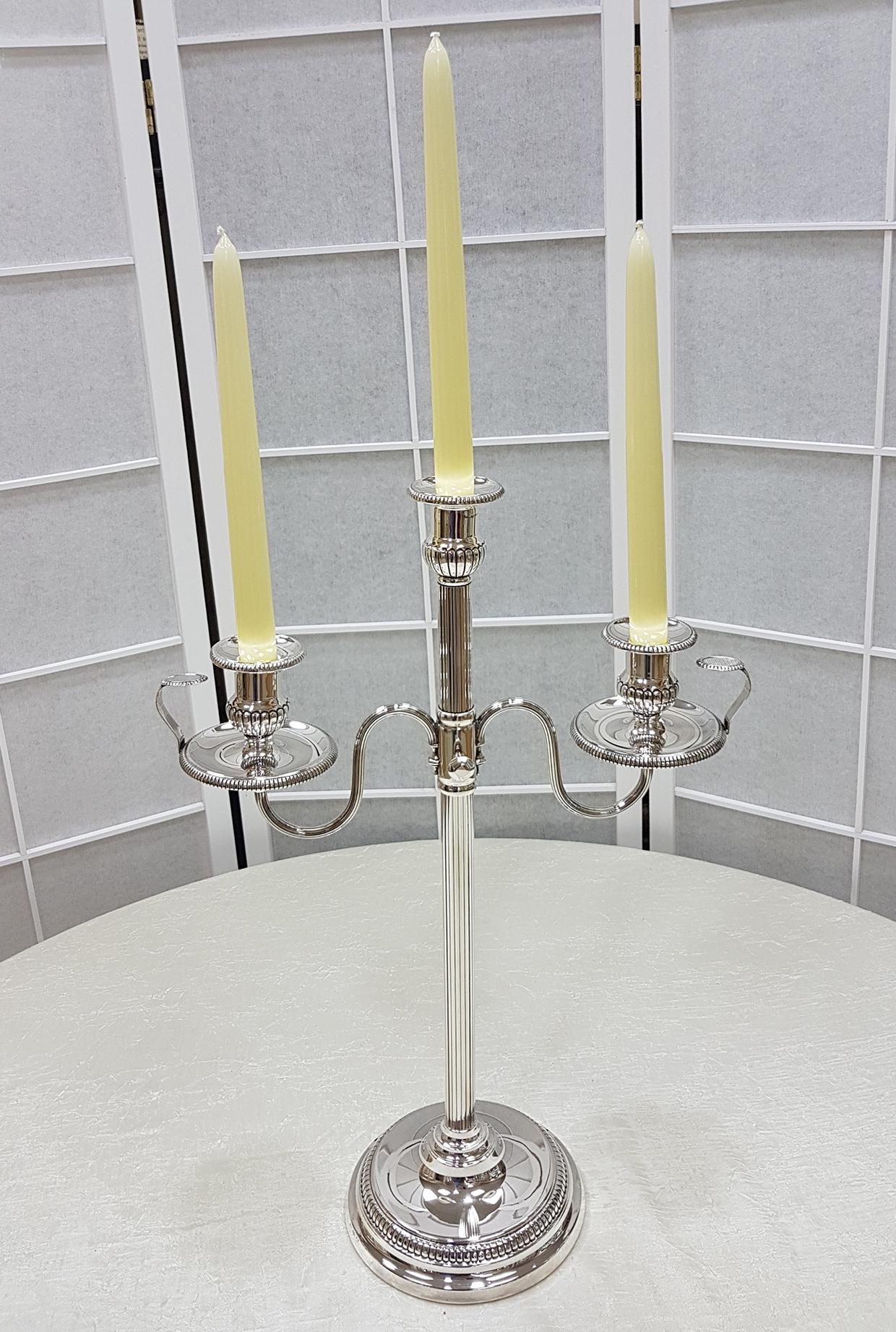 Elegante candelabro de plata de ley 925 con tallo central y brazos rayados.
Los dos portavelas laterales son desmontables y se convierten en dos cámaras garrapatas cm. 11 H. 5.5 .
Los portavelas 