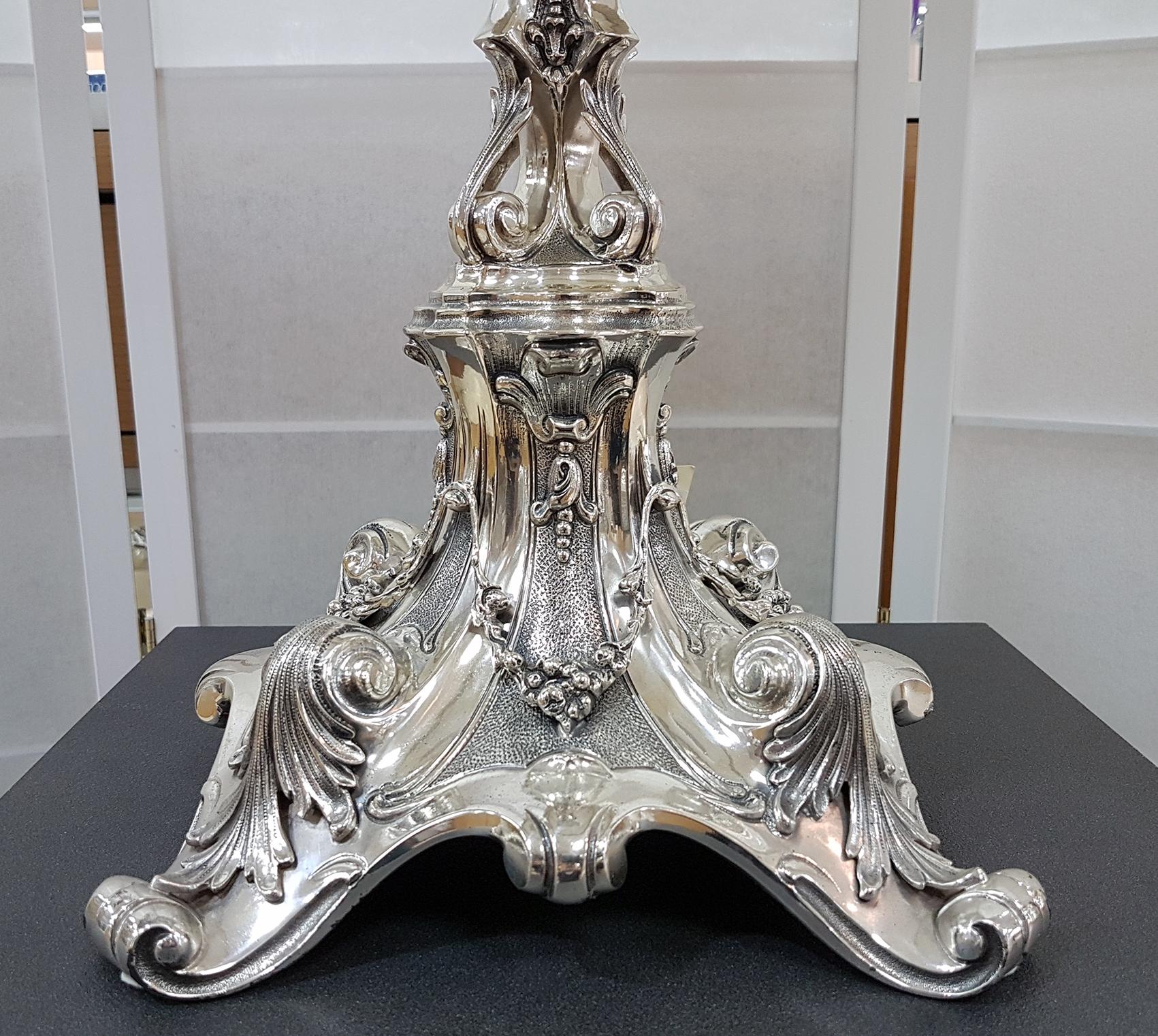 Superb lamp in solid sterling silver completely worked, embossed and hand chiselled. The square base and the stem are enriched with acanthus leaves, fruits and leaflets, typical of the Baroque style.
Its imposing size is suitable for environments