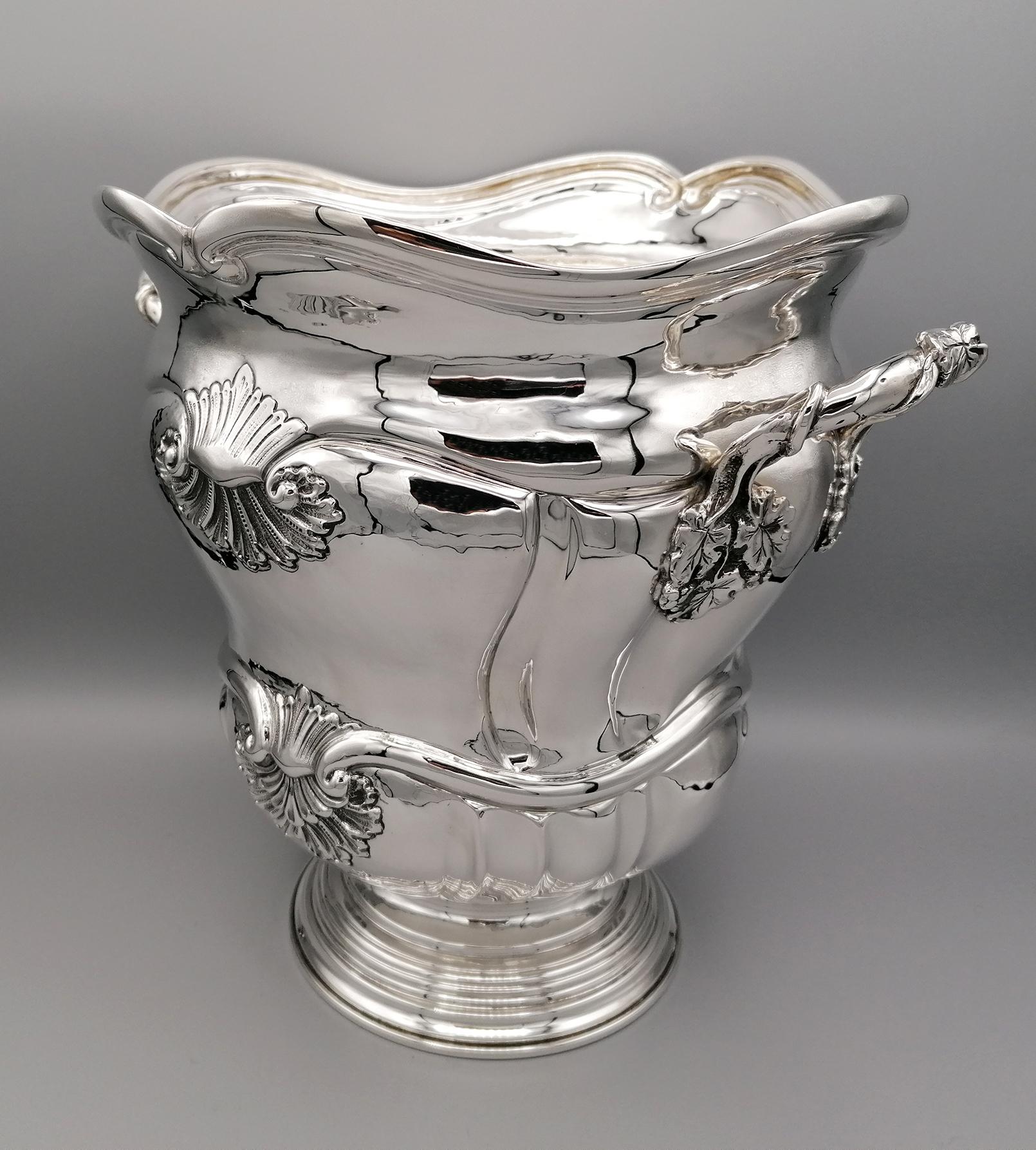 Gorgeous handmade sterling silver champagne bucket.
The body is shaped, embossed and chiseled completely by hand.
Four shells of two different sizes, typical of the Baroque style, have been embossed and chiseled in a symmetrical way.
Two large