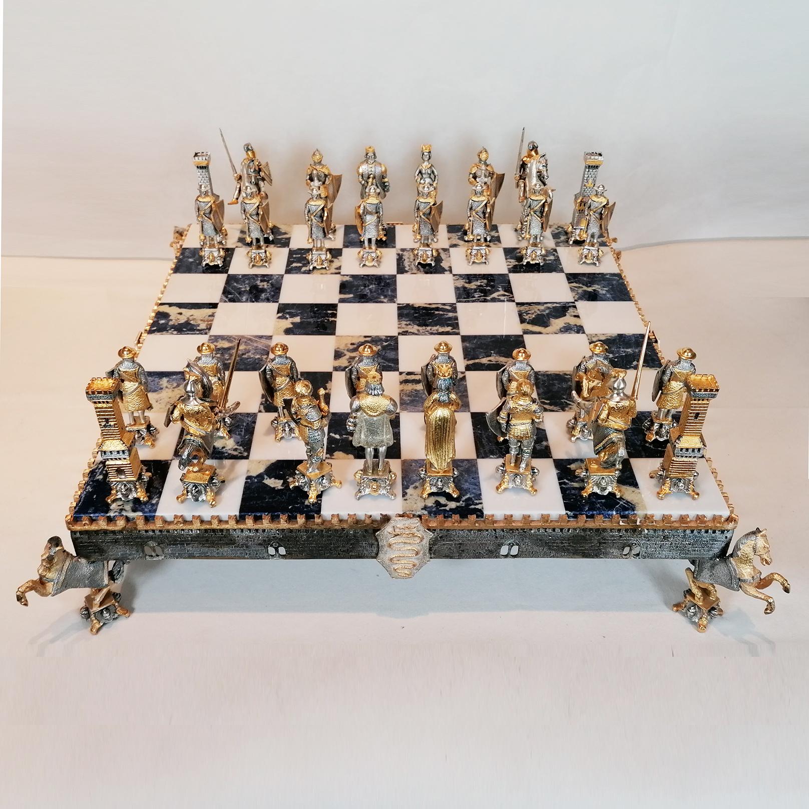 Impressionnant jeu d'échecs en argent sterling de style médiéval.
L'échiquier, réalisé par ARVAL ARGENTI VALENZA, en marbre blanc et sodalite, est soutenu par un cadre en ARGENT STERLING réalisé selon la méthode de la fonte et fini au ciseau,