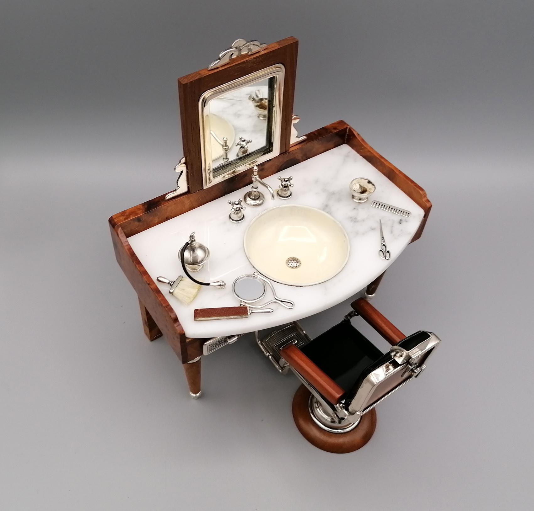 Extraordinary miniature representing the barber shop. The structure is in briar and the details (comb, brush, mirror, taps, scissors, etc.) are in 925 silver.
The tabletop is in Carrara marble.
The chair and washbasin are in enameled 925 silver.
The