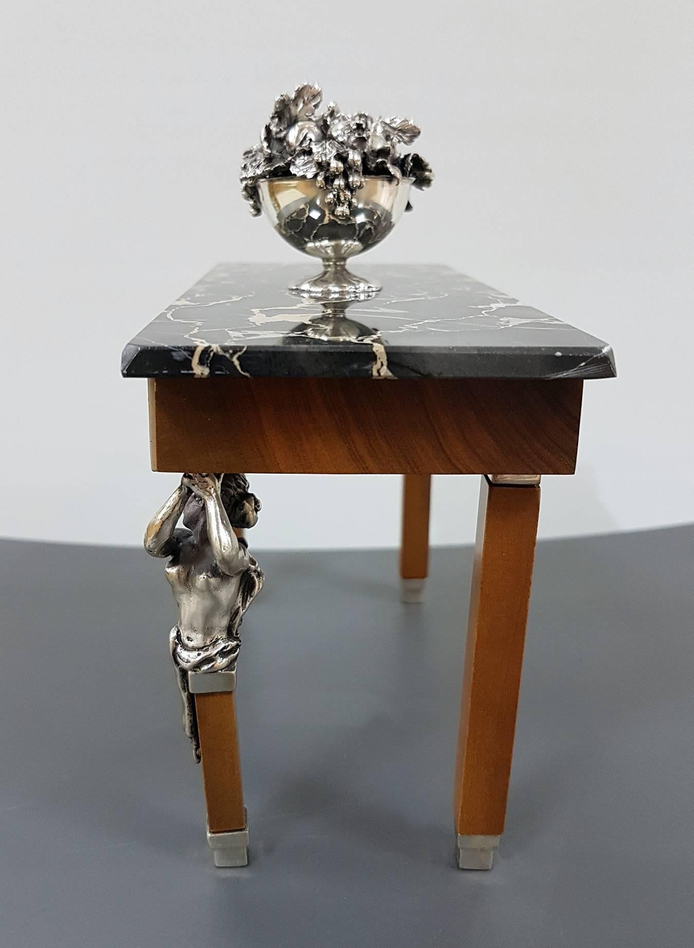 The table is sterling silver with marble top and structure in precious wood.
The figures, the friezes and the fruit basket are in sterling silver


 