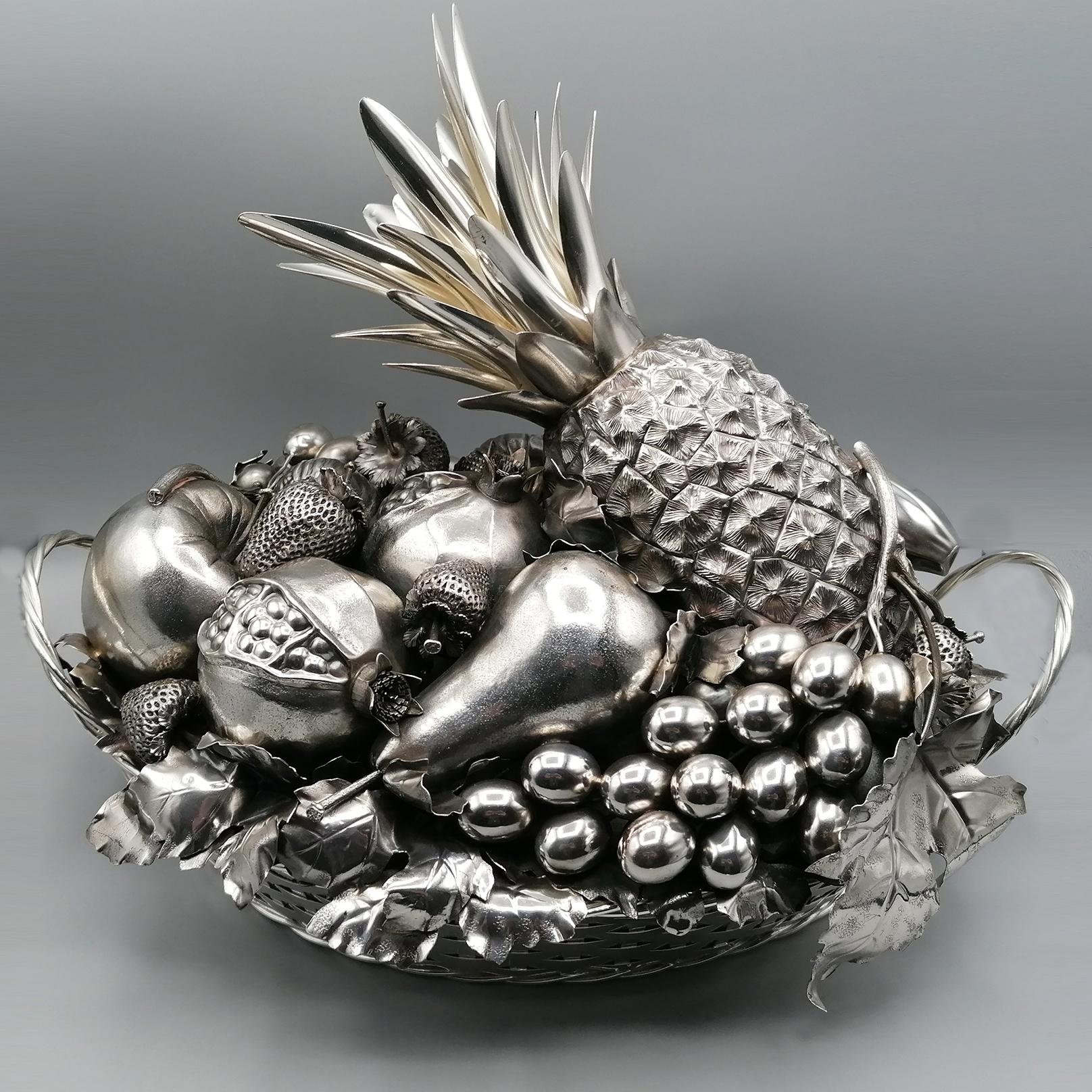 Sterling silver centerpiece made in two parts.
The bottom is an oval braided basket with two handles.
The top reproduces a triumph with various types of fruit.
Pineapples, grapes, pomegranates, strawberries, apples, bananas, etc

3,715 grams.