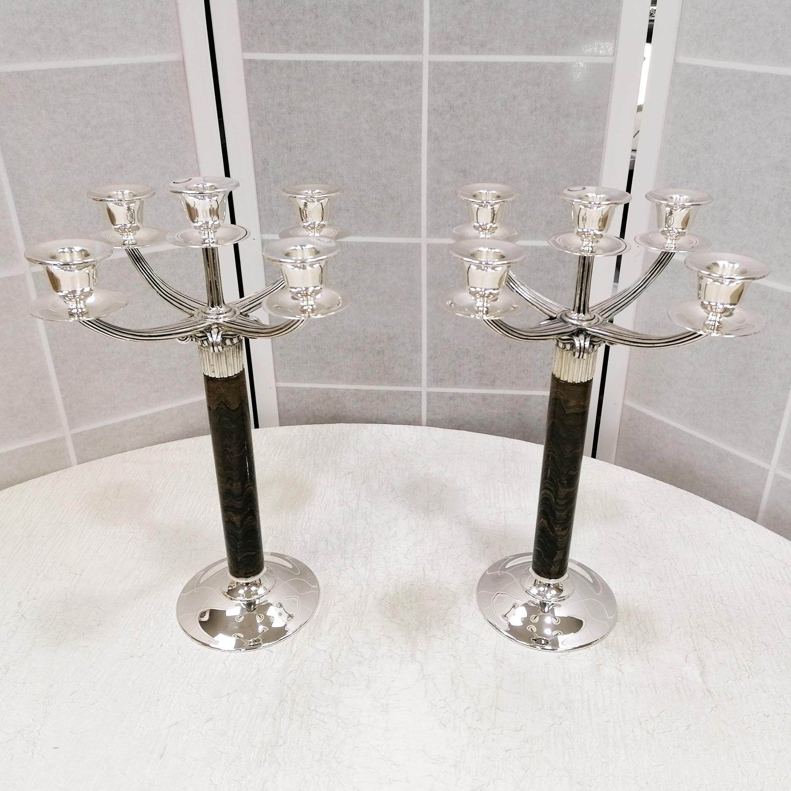Pair of 5-light candelabra in 925 sterling silver in neoclassical style.
Candelabra formed by an iron eye stem and a Hellenic part in Ionic style in 925 silver.
The iron eye is a stone that brings mental and physical benefits. 
Its union with silver