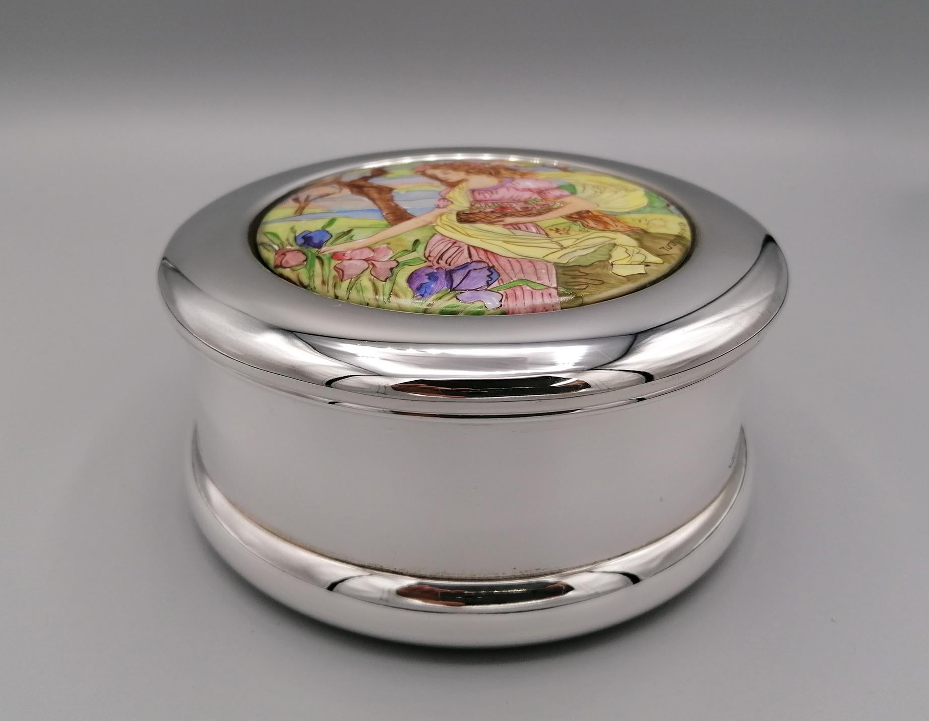 Smooth round 925 sterling silver box.
The lid was modeled to be able to apply a Limoges porcelain, subsequently hand painted in polychrome with a female figure picking flowers.
On the porcelain there is an inscription in Italian that says:
TUTTO