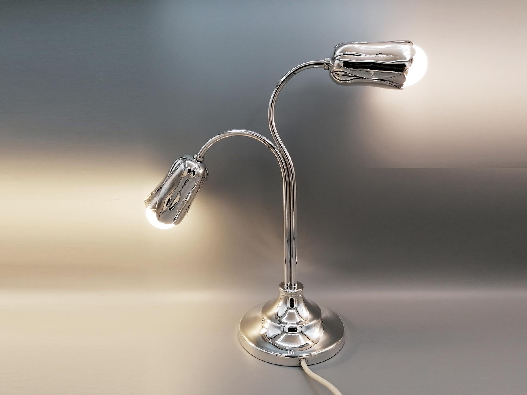 Two light solid sterling silver lamp.
The base is round while the stem has a double empty tubes where the electric wire passes.
The lamp holders are in the shape of a tulip flowers in fusion and with a chisel finish.
Italian silverware, already with