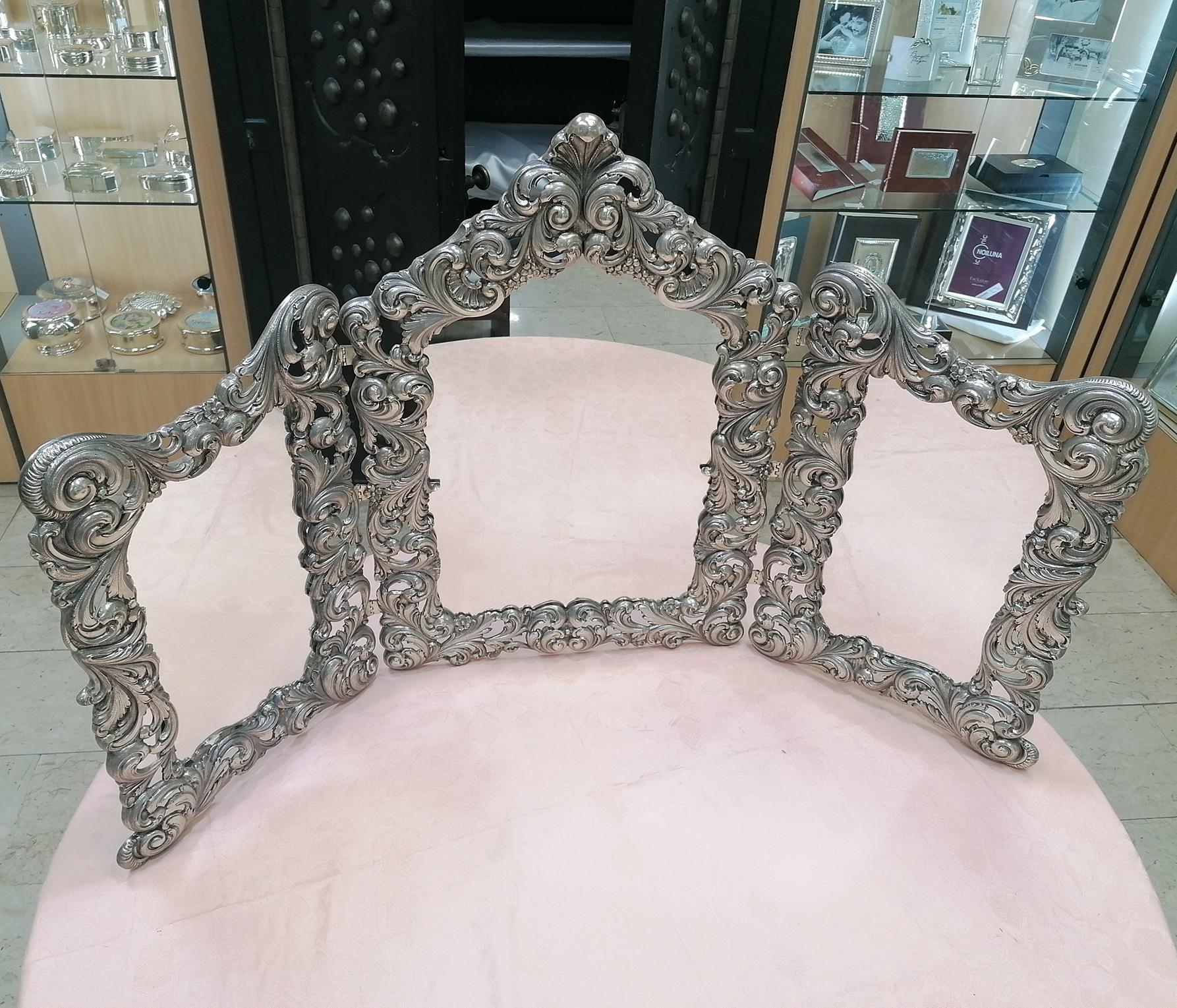 This Italian Baroque style Sterling Silver mirror is fully hand embossed and chiselled on silver sheet by hand. The two side mirrors are attached by silver hinges. 
4.600 grams.

Italian silverware, already with a centuries-old tradition, had a