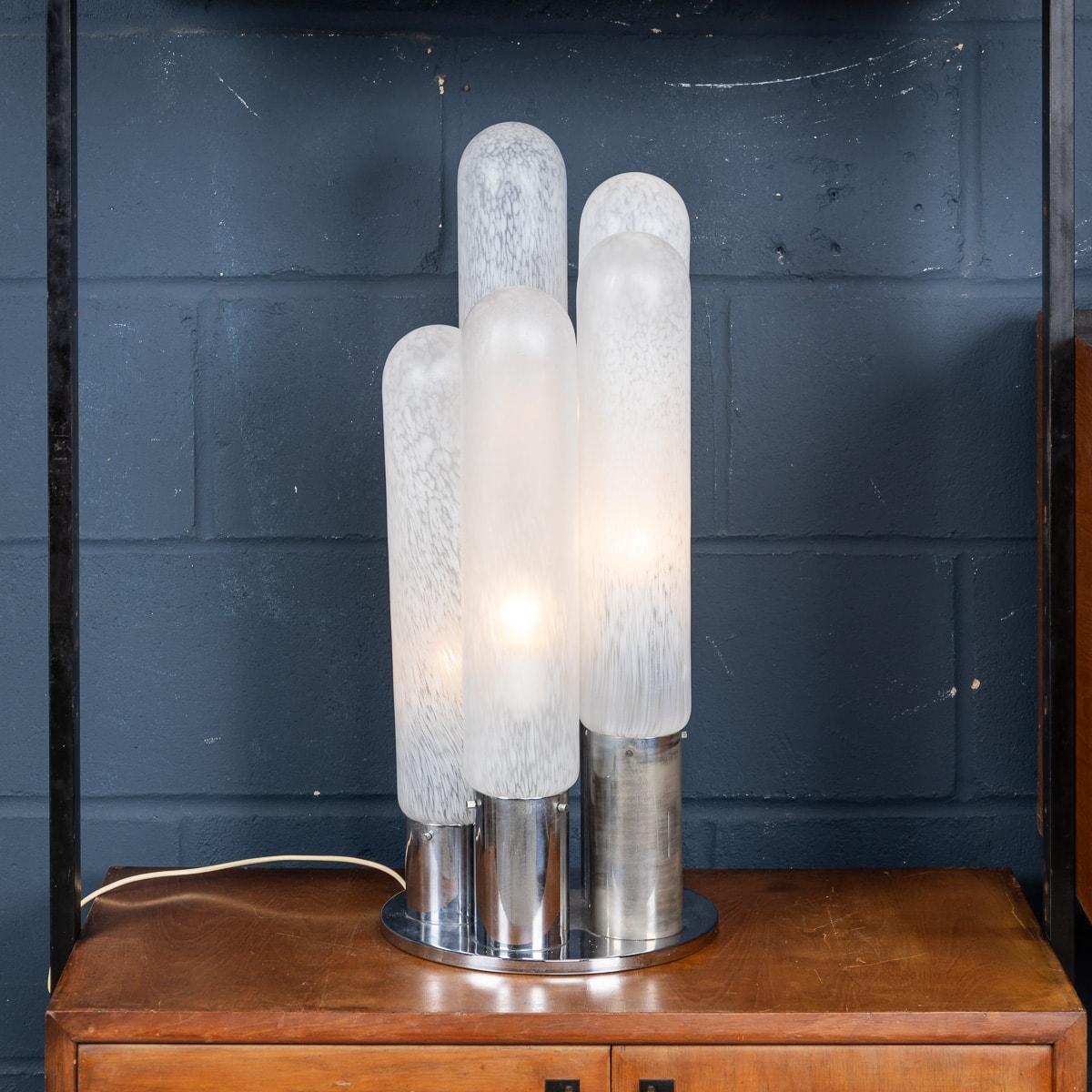 Une élégante lampe de table conçue par Carlo Nanson pour Mazzega dans les années 1970. Elle se caractérise par une structure tubulaire chromée supportant cinq tubes en verre opalin soufflé à la main. Le verre blanc laiteux passe au translucide et à