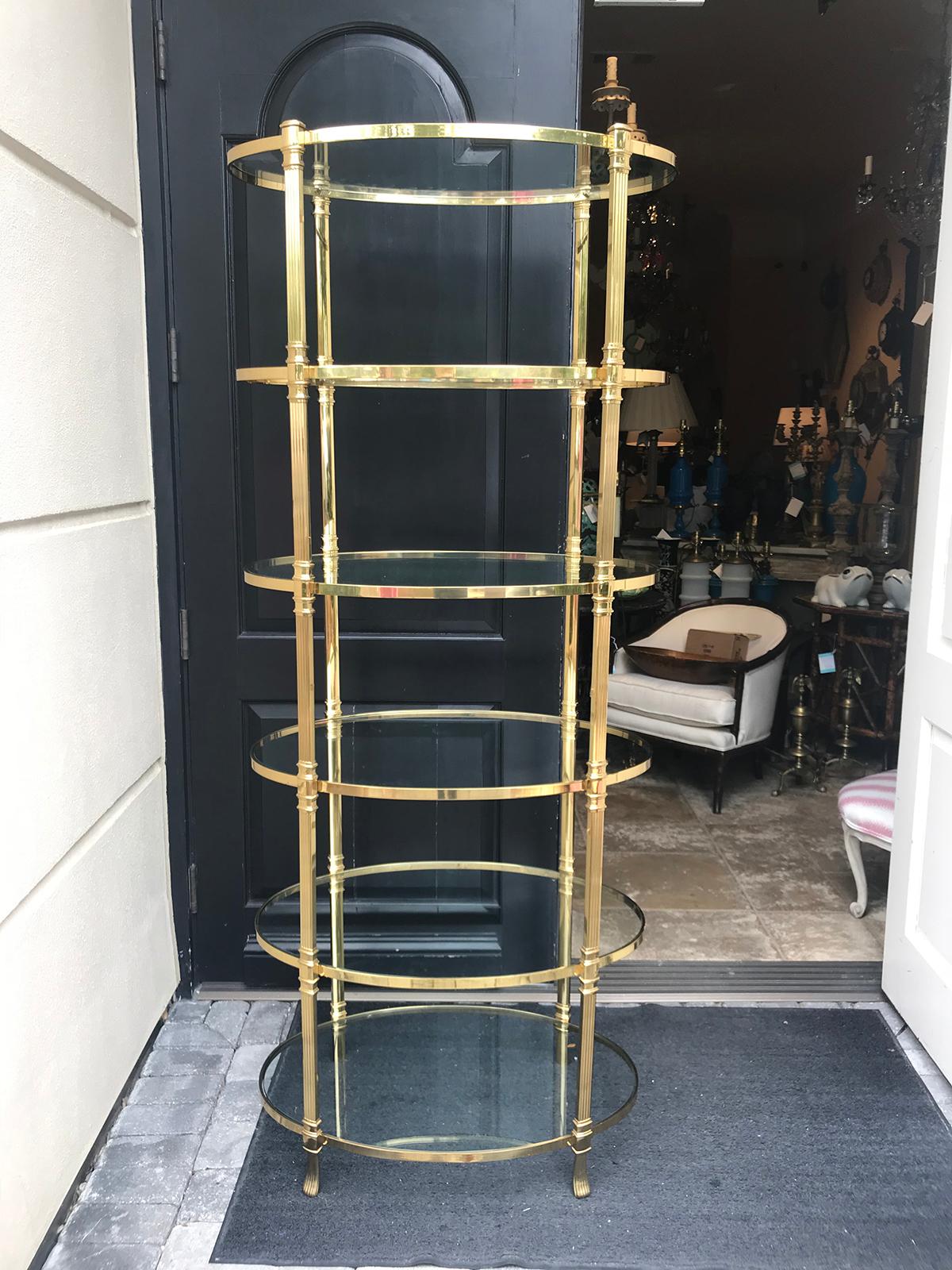 20th century Italian tall brass oval étagère with glass shelves, in the style of Baguès.