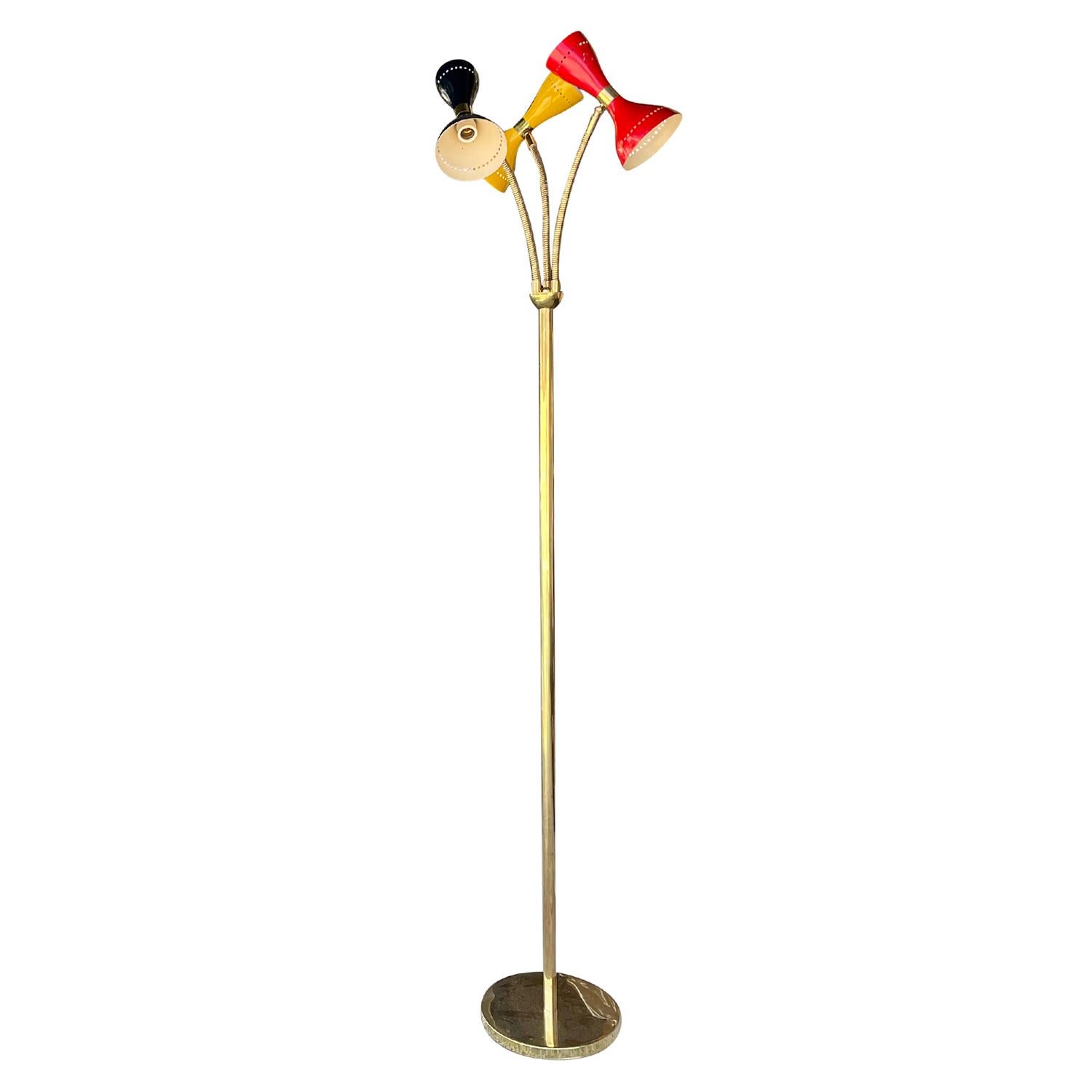 A tall colorful, vintage Mid-Century Modern Italian floor lamp made of hand crafted metal and brass, composed with one black, yellow and a red shade, produced by Stilnovo in good condition. The three conical mount, perforate metal shades are