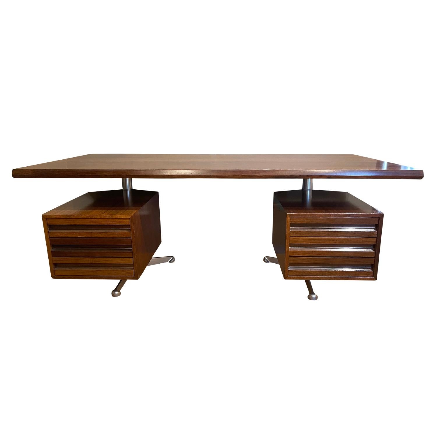 A vintage Mid-Century Modern Italian writing table made of hand carved rosewood, designed by Osvaldo Borsani and produced by Tecno, in good condition. The desk is composed with a large table top, six drawers, three on each side, standing on a steel