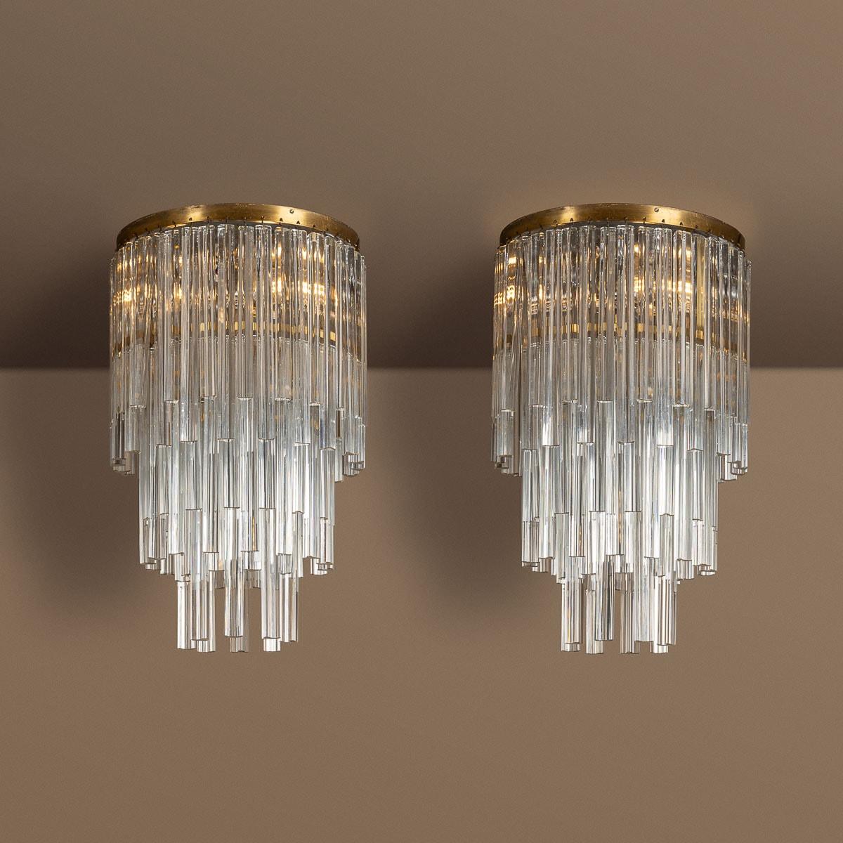 Crafted in Murano, Italy by Venini during the 20th century, this pair of chandeliers embodies a unique and exquisite style. The chandelier's structure is meticulously fashioned from high-quality Murano glass. Its pendant design boasts long, graceful