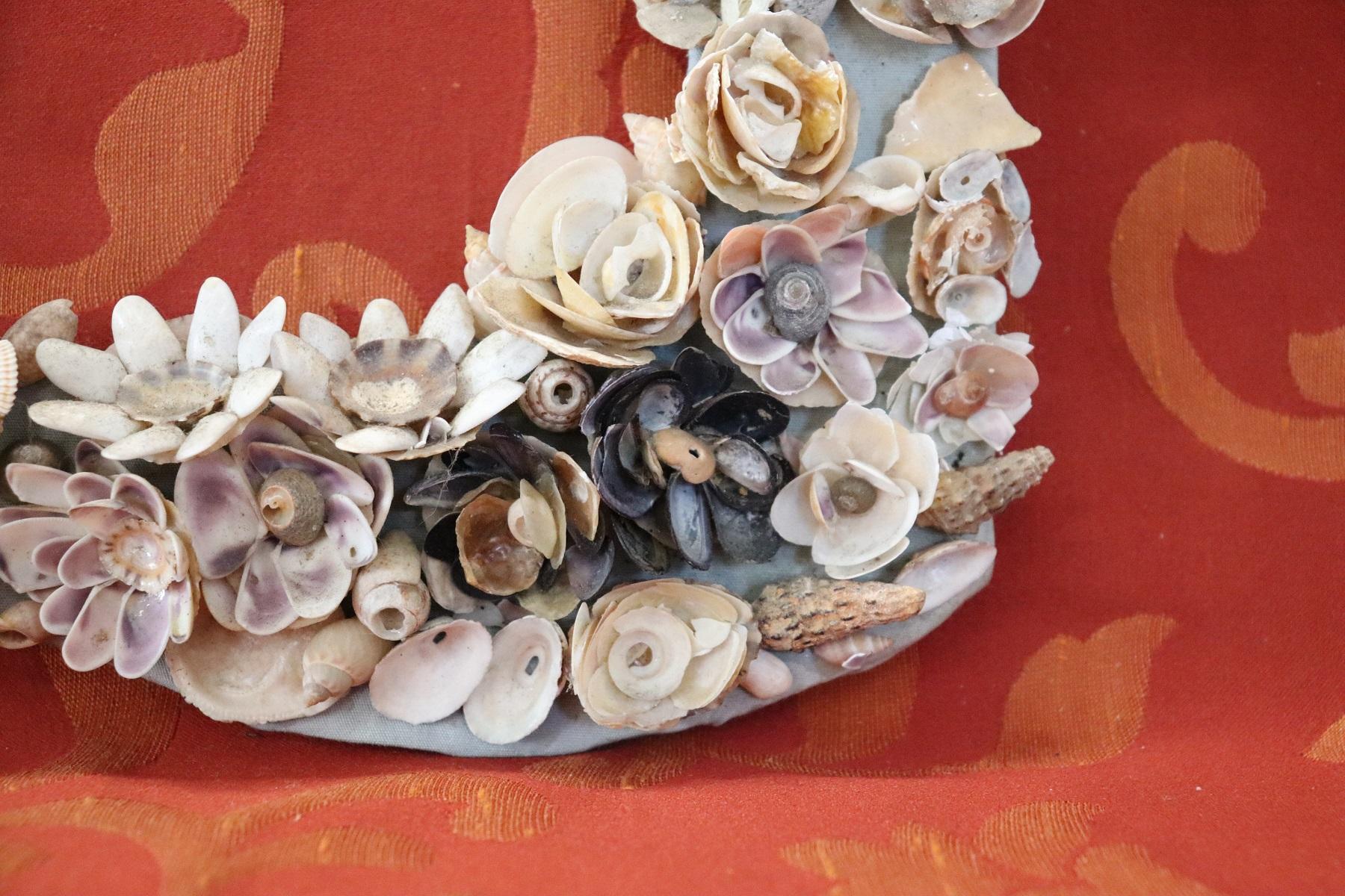 Italian artistic photo frame made entirely with small shells. The shells have been positioned so as to create many small flowers. Glued on cardboard. Sold in the conditions as photos do not have glass and wall hooking. Possible some small missing