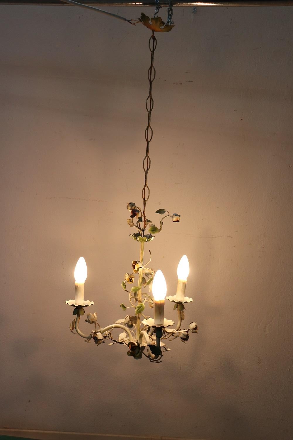 Nice Italian vintage chandelier in forged iron 3-light, 1930s. Floral decoration with delicate roses sprouting from loose leaves. The iron is painted in light green and different delicate colors for the flowers. Perfect for your home.