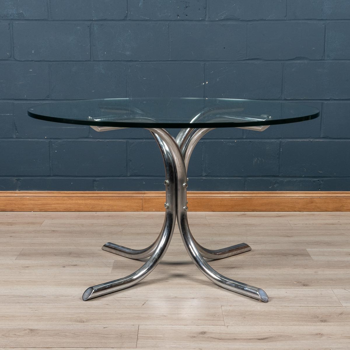 An elegant dining table designed and made in Italy around the 1970's. Blending industrial design with art, the tubular structure supports a thick circular glass, 120cm in diameter. A lovely piece of mid century industrial design perfect for any home