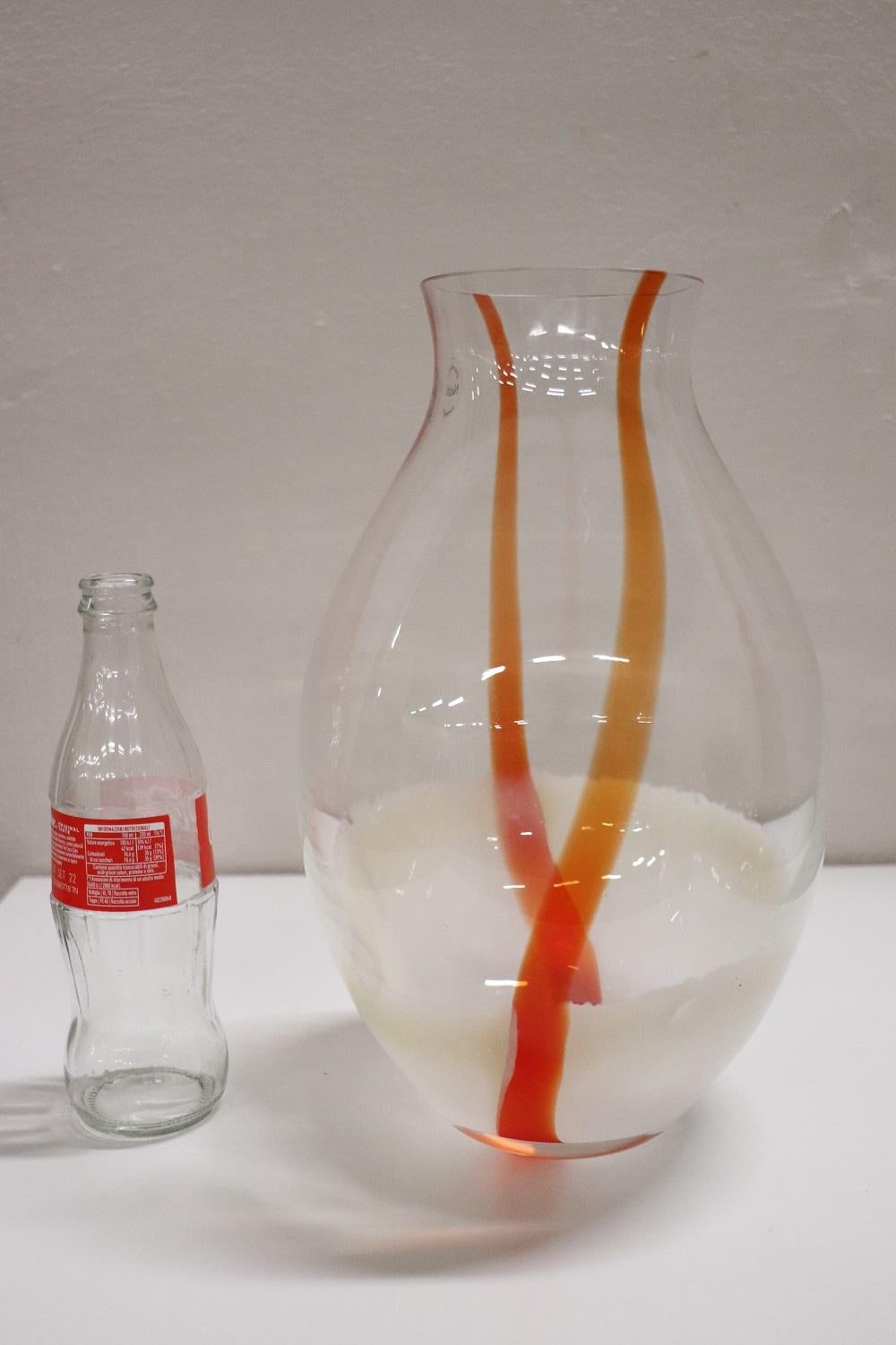 Refined artistic glass vase, Italy, production circa 1980s Murano. Original brand present in Nason production. Large vase with a particular design, in transparent glass that turns into milky white in the lower part, crossed by an orange band.