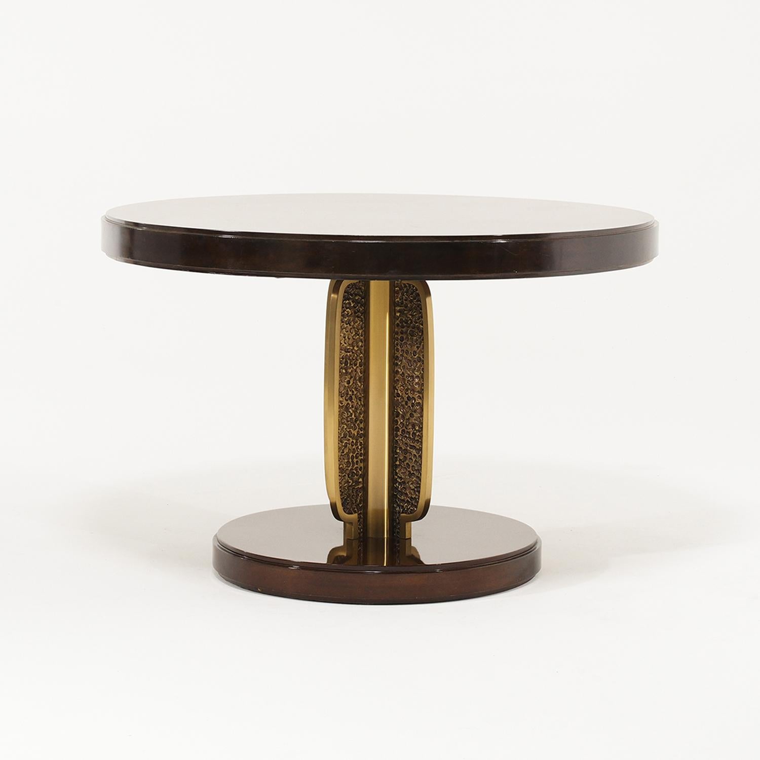 A vintage Mid-Century Modern Italian center, game table made of handcrafted polished Walnut, designed by Luciano Frigerio in good condition. The tick round top is supported by a sculptural polished bronze leg which is resting on a wooden base. Minor