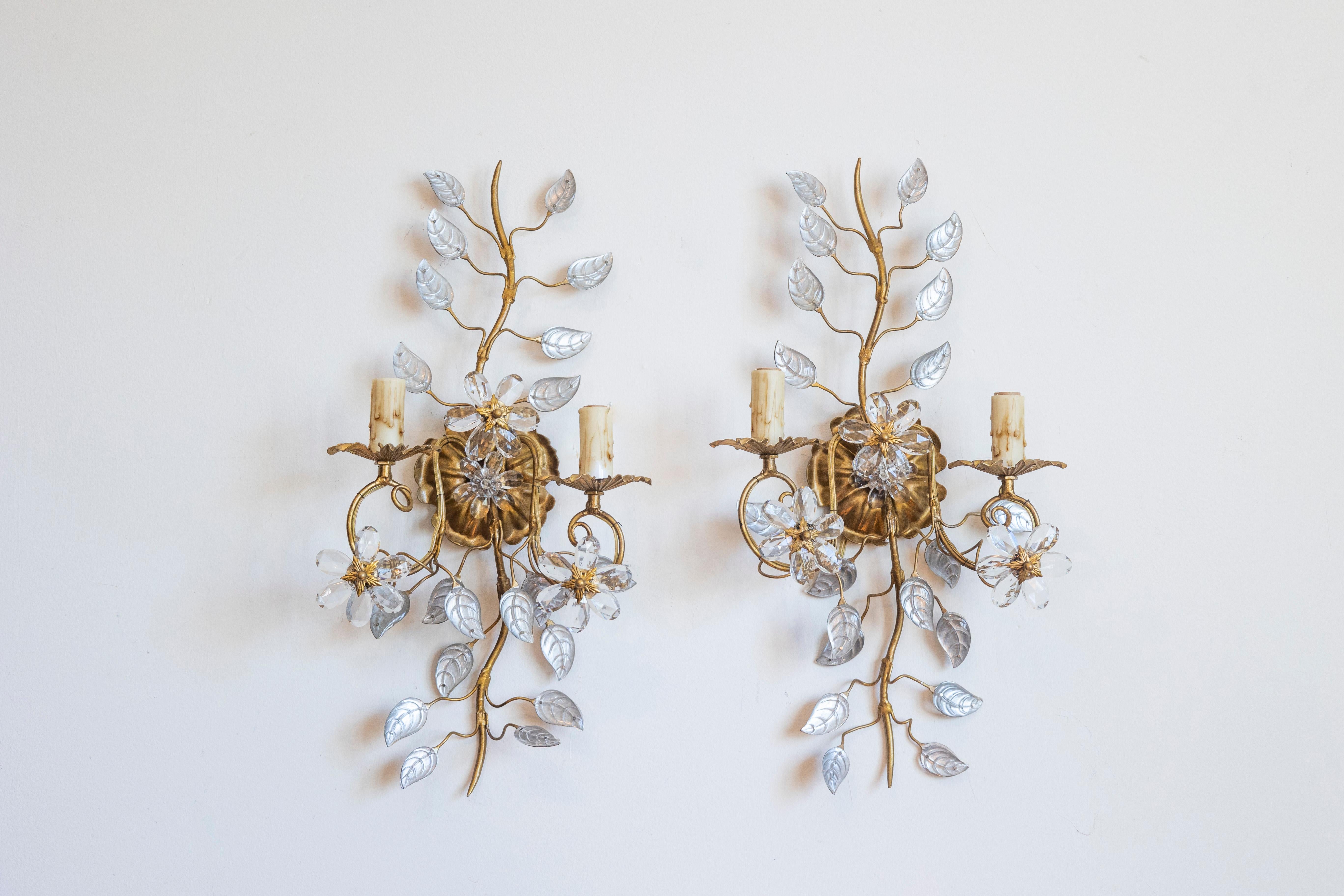 Questa splendida coppia di appliques italiane del XX secolo incarna l'eleganza e la maestria senza tempo. Ogni applique è splendidamente realizzata a mano in metallo dorato, con un design organico a forma di vite che scorre, ornato da delicati fiori