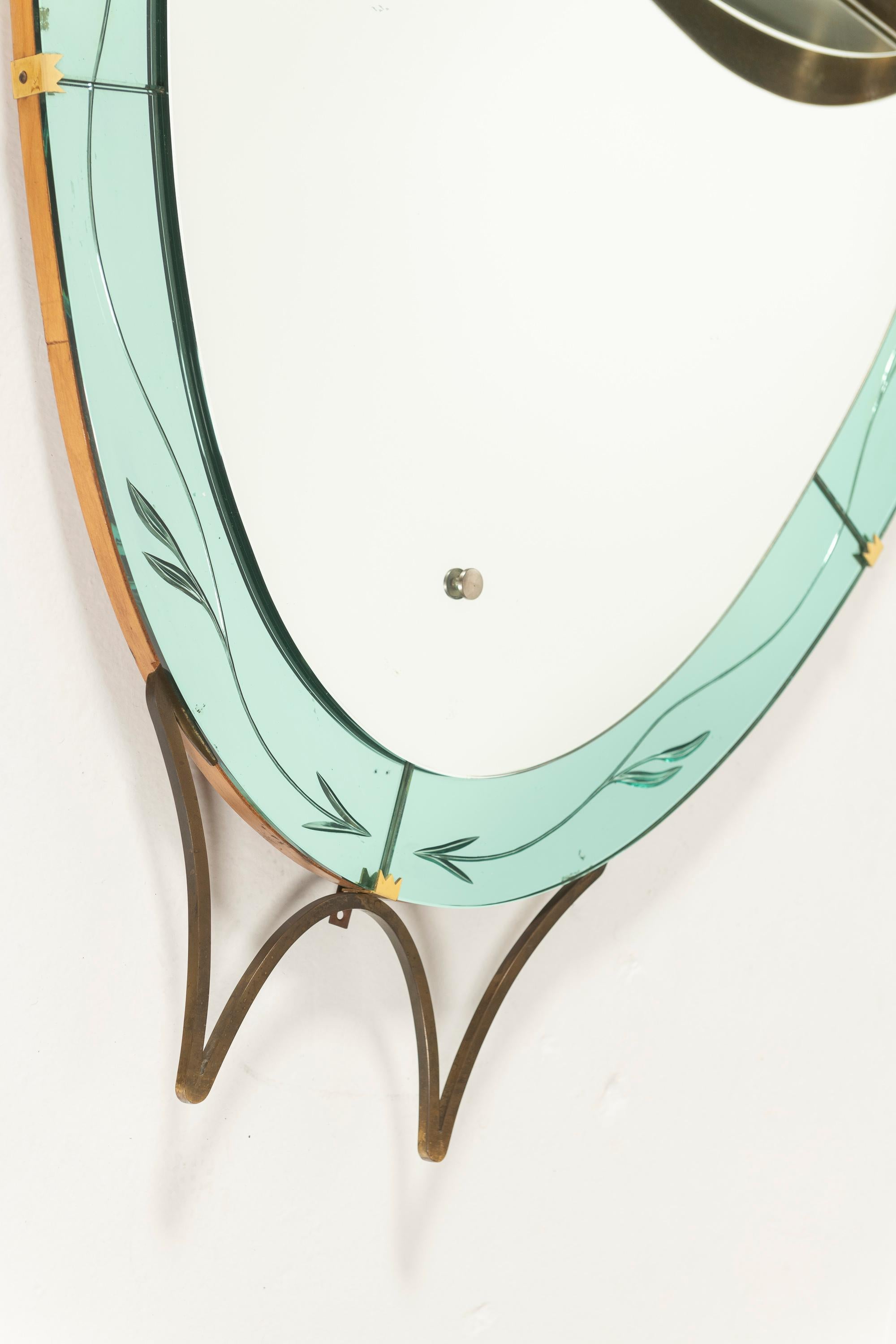 Ce magnifique miroir est attribué à Cristal Arte au début des années 1950.  de forme ovale avec un sommet cannelé. Elle présente une bordure en cristal de couleur vert menthe avec un cadre et une garniture en laiton, ainsi qu'une épaisse tablette en
