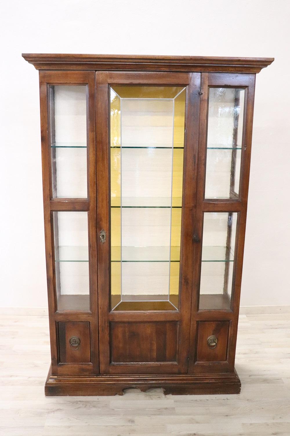 Italian luxury furniture 1950s in walnut wood. Very linear and essential perfect to be combined even in a modern home. Precious antique cathedral glass with yellow decoration. The upper part with glass doors is perfect for displaying your collection