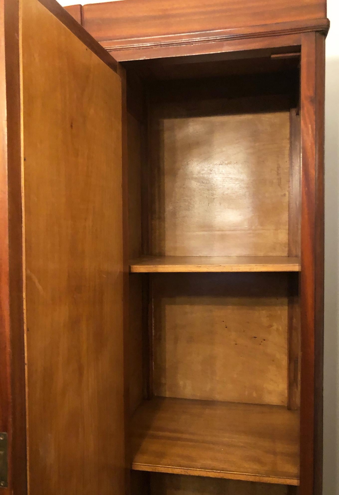 20th Century Italian wardrobe with two doors in original walnut color with mirrors.
The wardrobe is made up of two mahogany blocks joined together, with two drawers at the bottom and a mirrored door at the top and a clothes rail with internal