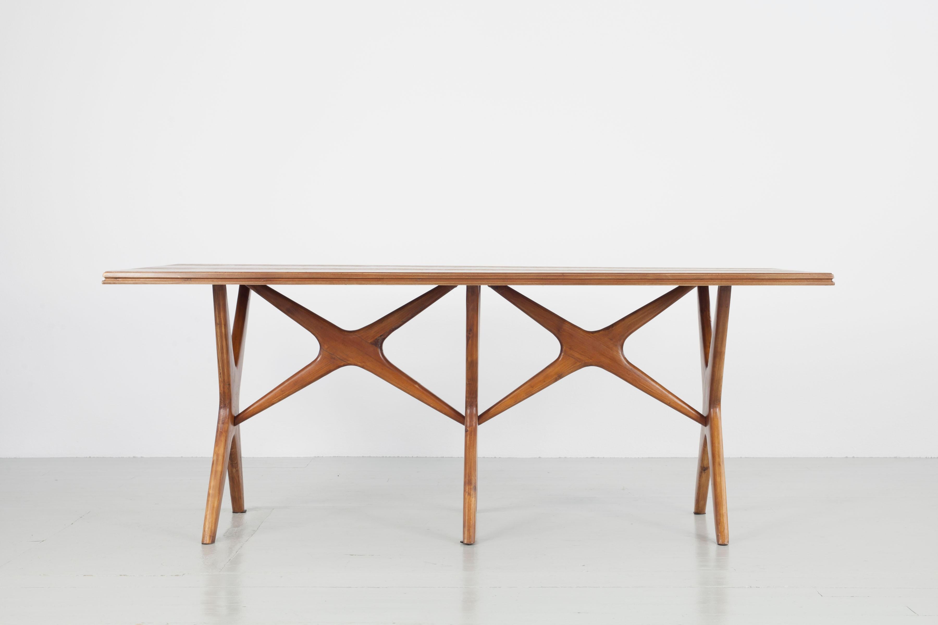 Dining Table with recurring cross motive in table legs and strutting. This is a particular interesting design element because form and function are tied very close together. The roundness of the structural element creates texture and elegance within