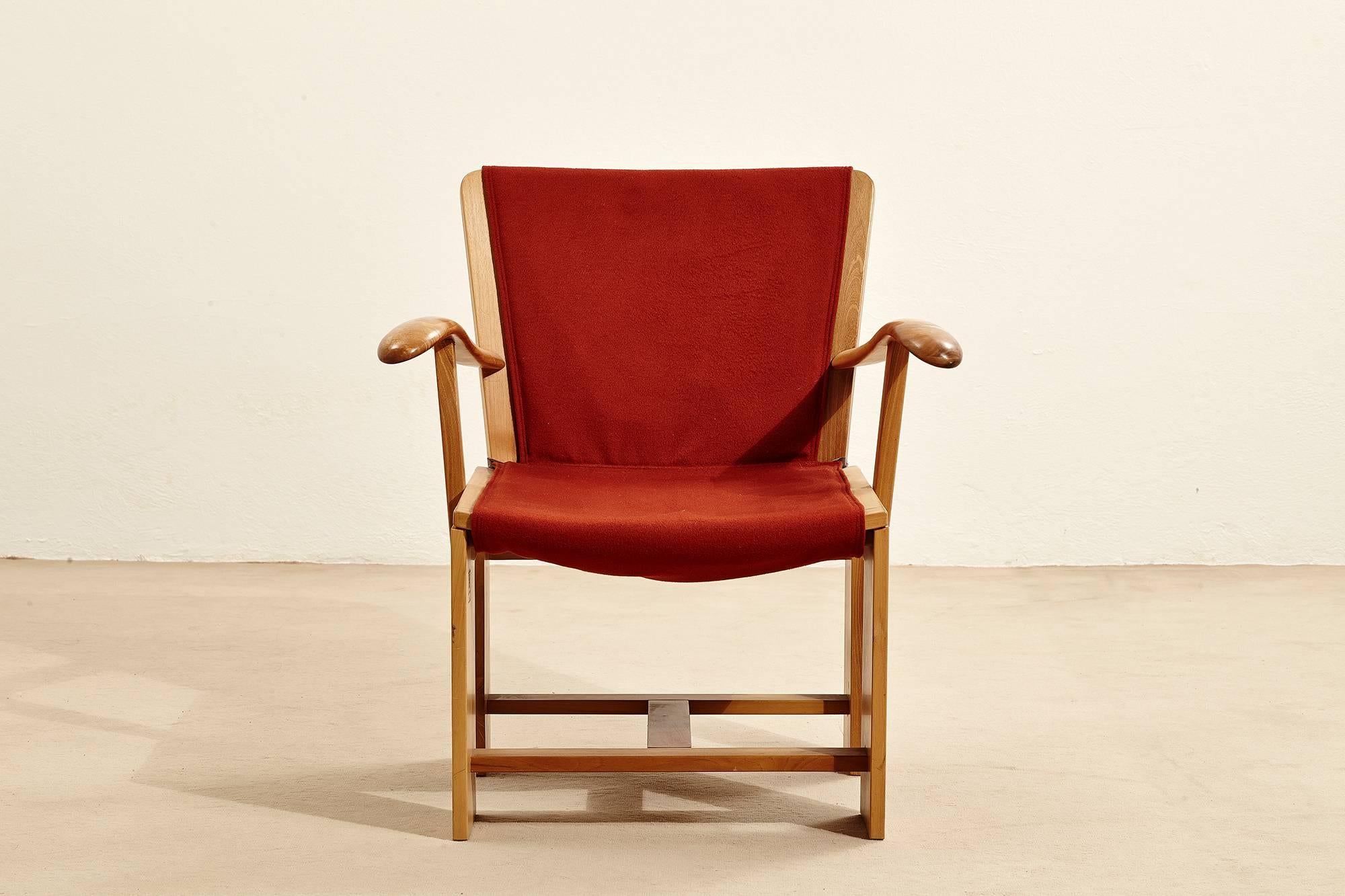Armchair in natural walnut wood with double-faced, rust-colored upholstery. Designed by Carlo Scarpa for Italian firm Bernini in 1977.
The is a small patch of white plaster on one of the armrests.