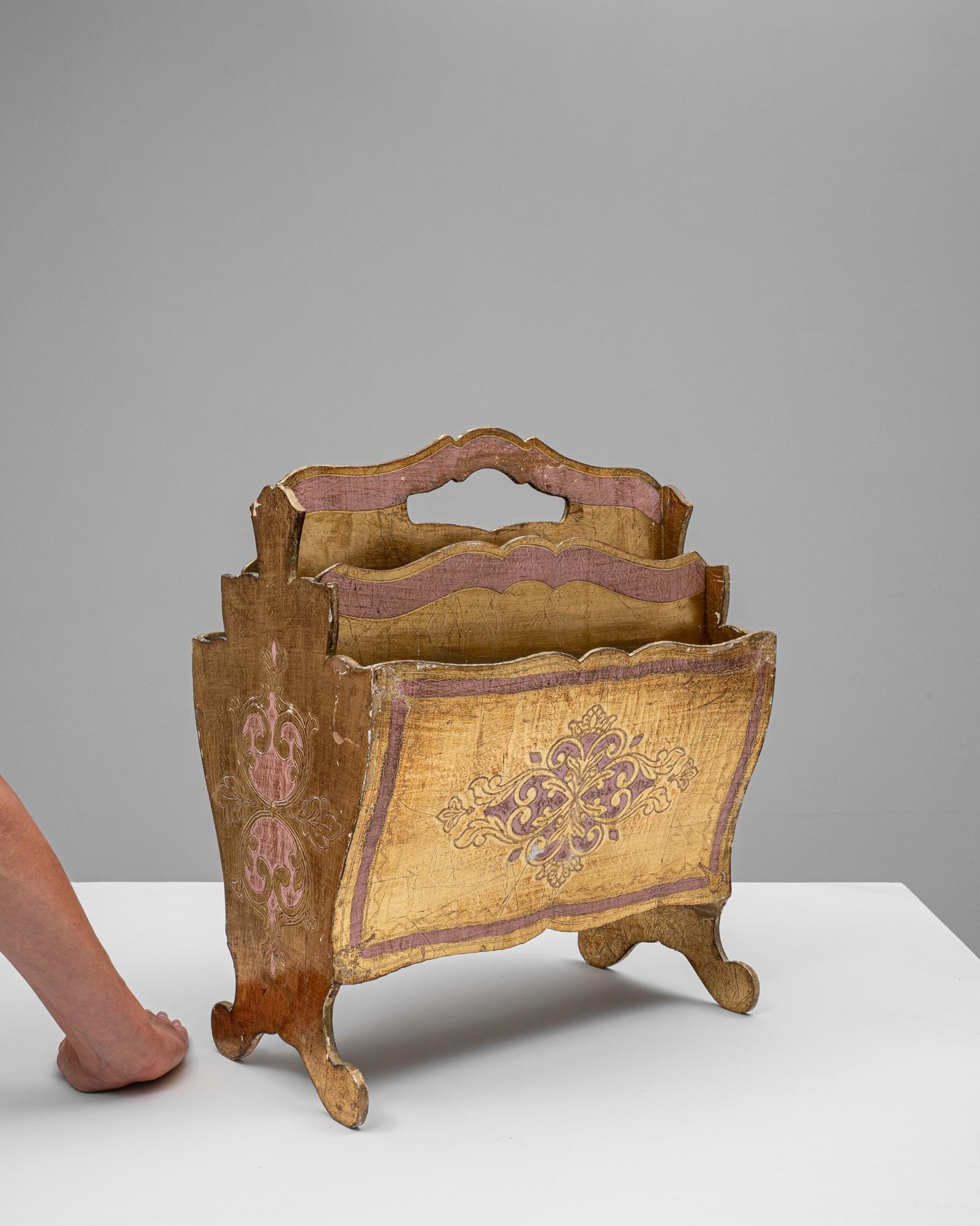 Ce porte-journaux en bois italien magnifiquement fabriqué à la main respire l'élégance intemporelle et la fonctionnalité. Avec ses motifs peints complexes en or et en rose discret, le design reflète l'art italien traditionnel. Ses pieds