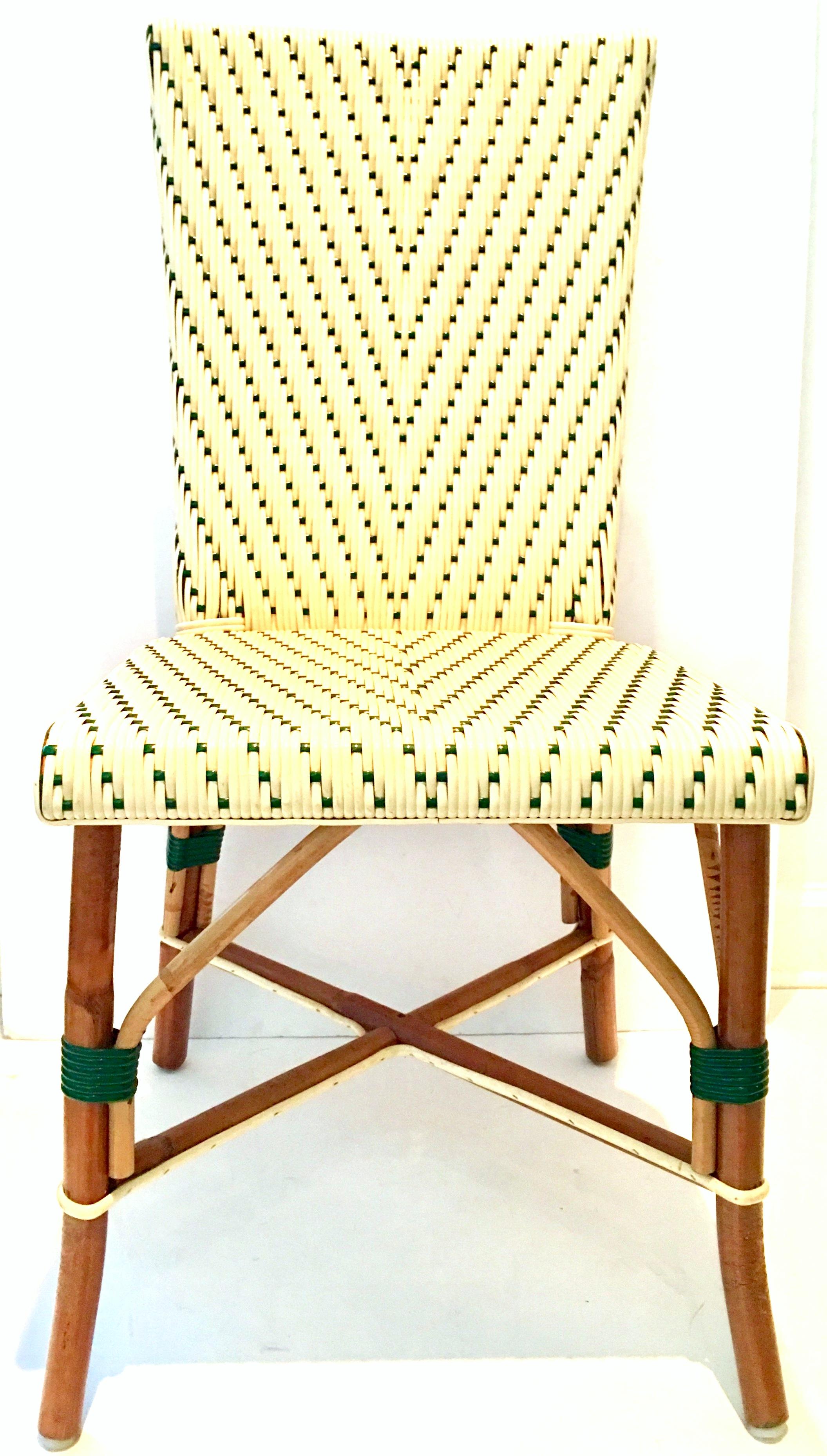 20th century Authentic Italian made woven vinyl and rattan Bistro chair. Hunter green and cream colored plastic handwoven back and seat with a rattan base and slanted legs. Features a cross bar rattan support. Chair is marked, Made in Italy on the