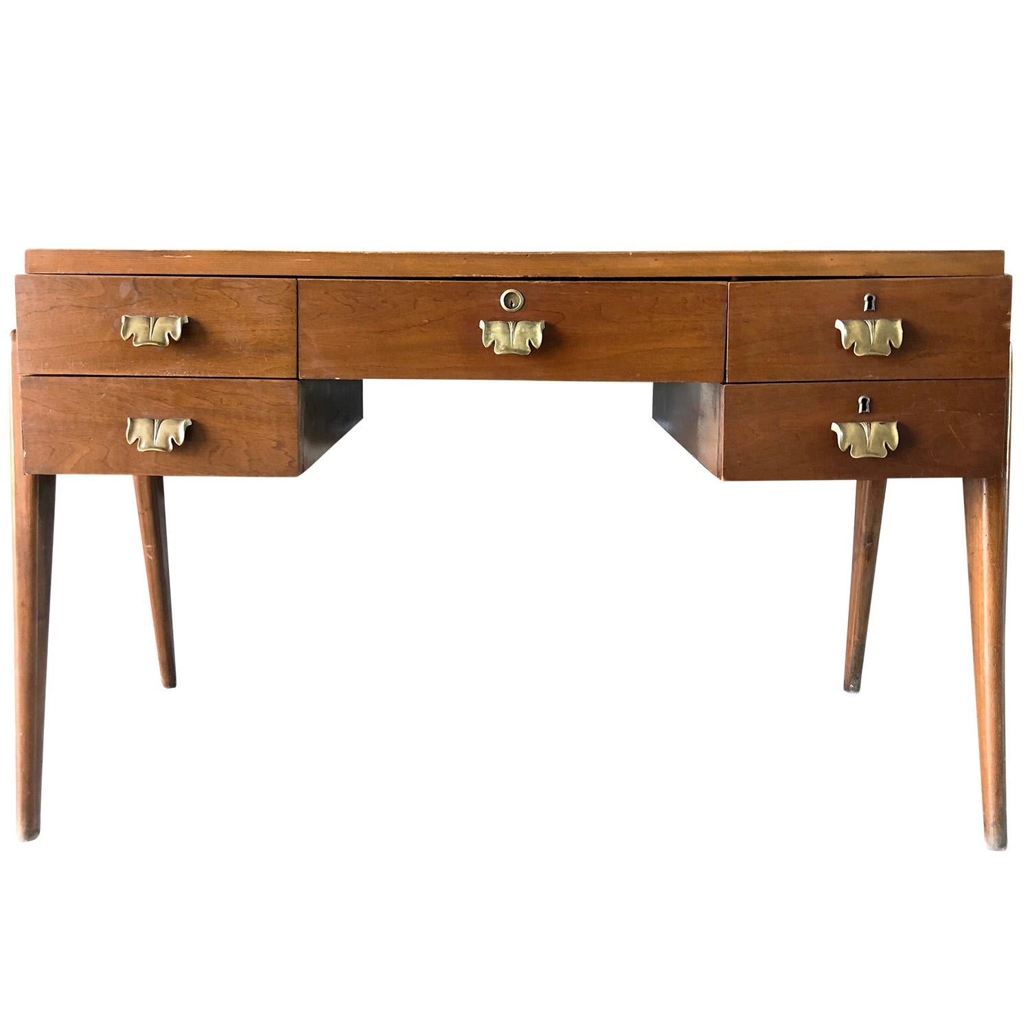 A vintage Mid-Century Modern writing desk or writing table with a green painted top. Designed by Paolo Buffa in good condition. The desk is made of walnut, enhanced by very detailed brass handles, composed with five drawers, standing of four