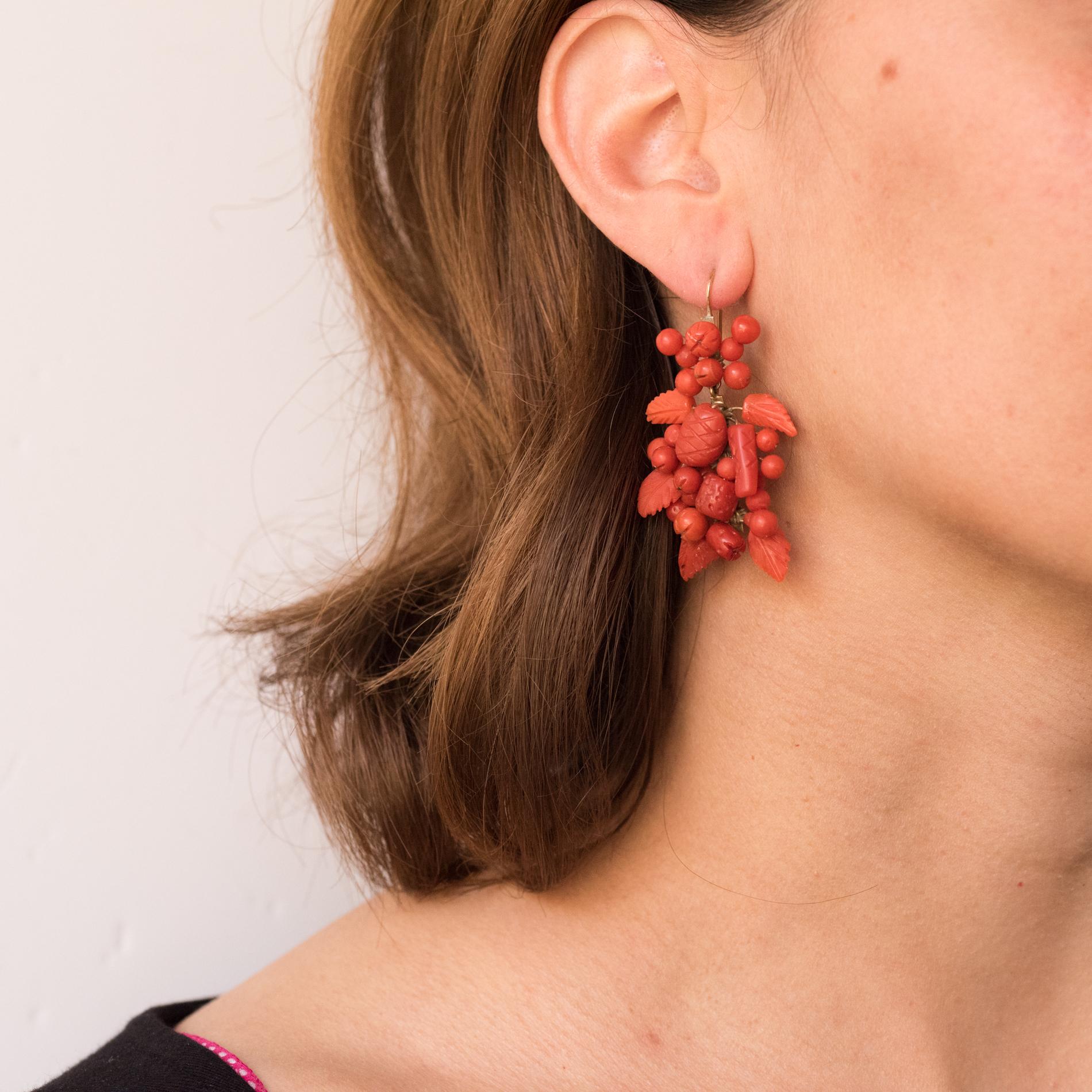 Coral earrings, they are made of a pattern composed of corals engraved with patterns such flowers, leaves and fruits that retains in a tassel another motif wich also consist of corals engraved with the same motifs. The clasp is a gooseneck in 14