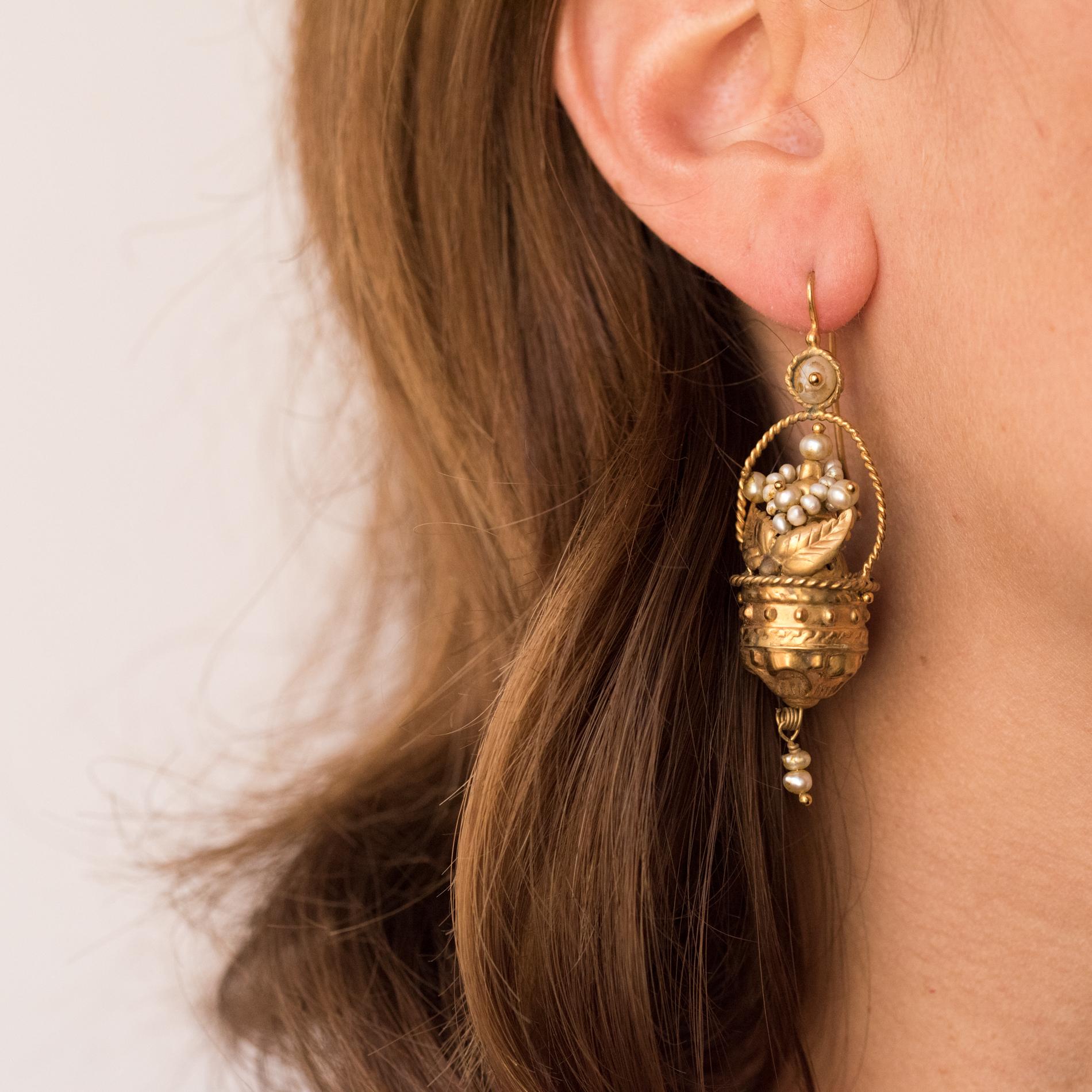 Earrings in 9 karats yellow gold.
These original and refined models are composed of a round motif set in its center of a natural half pearl and which holds in a tassel, a basket and its chiselled handle, trimmed with natural pearls, 2 small natural