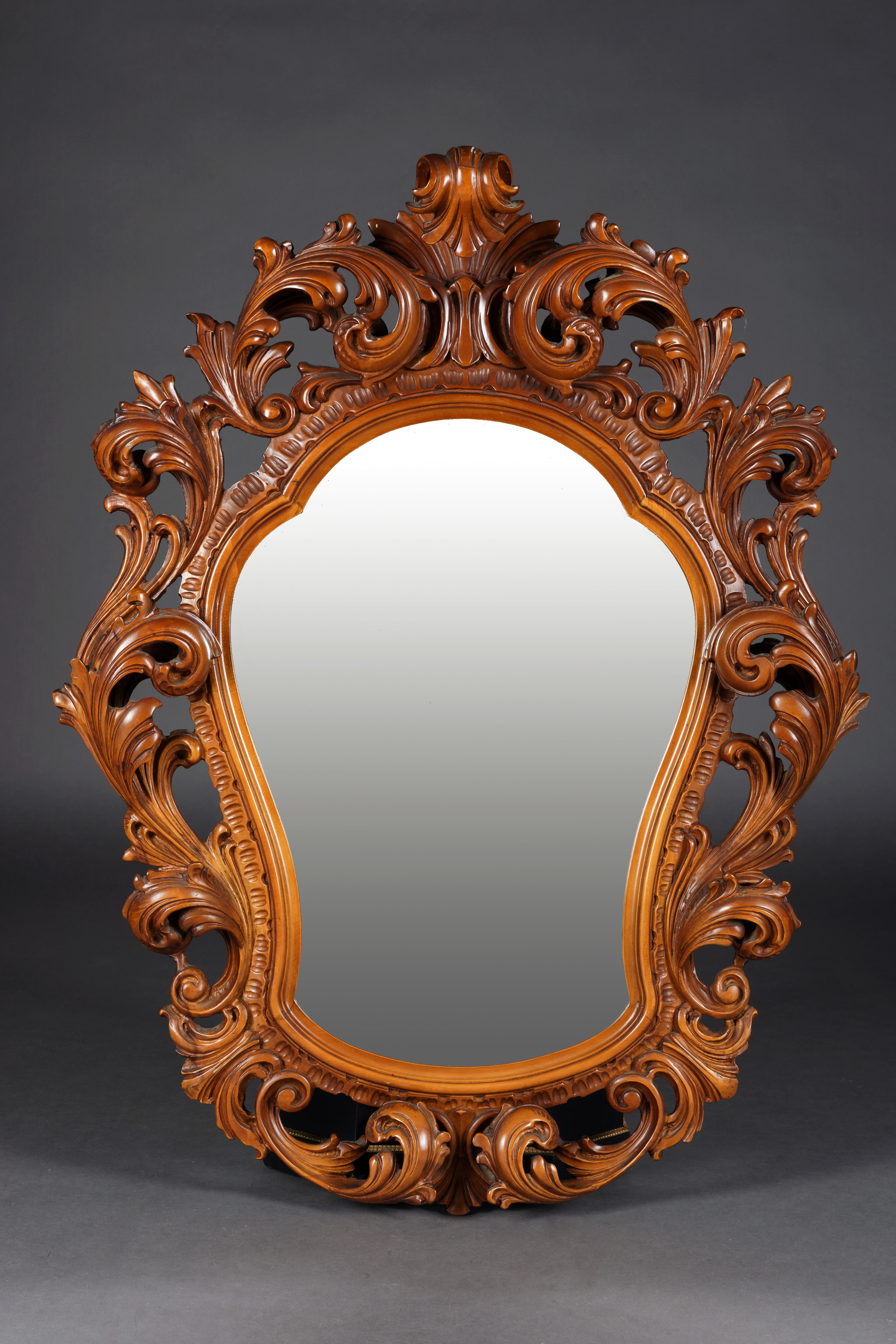 Monumental mirror in Rococo style
Walnut, finely carved. Highly shaped mirror-shaped mirror frame. Rich acanthus and rock carvings. Rich openwork rocaille carvings.

(M-13).
 
